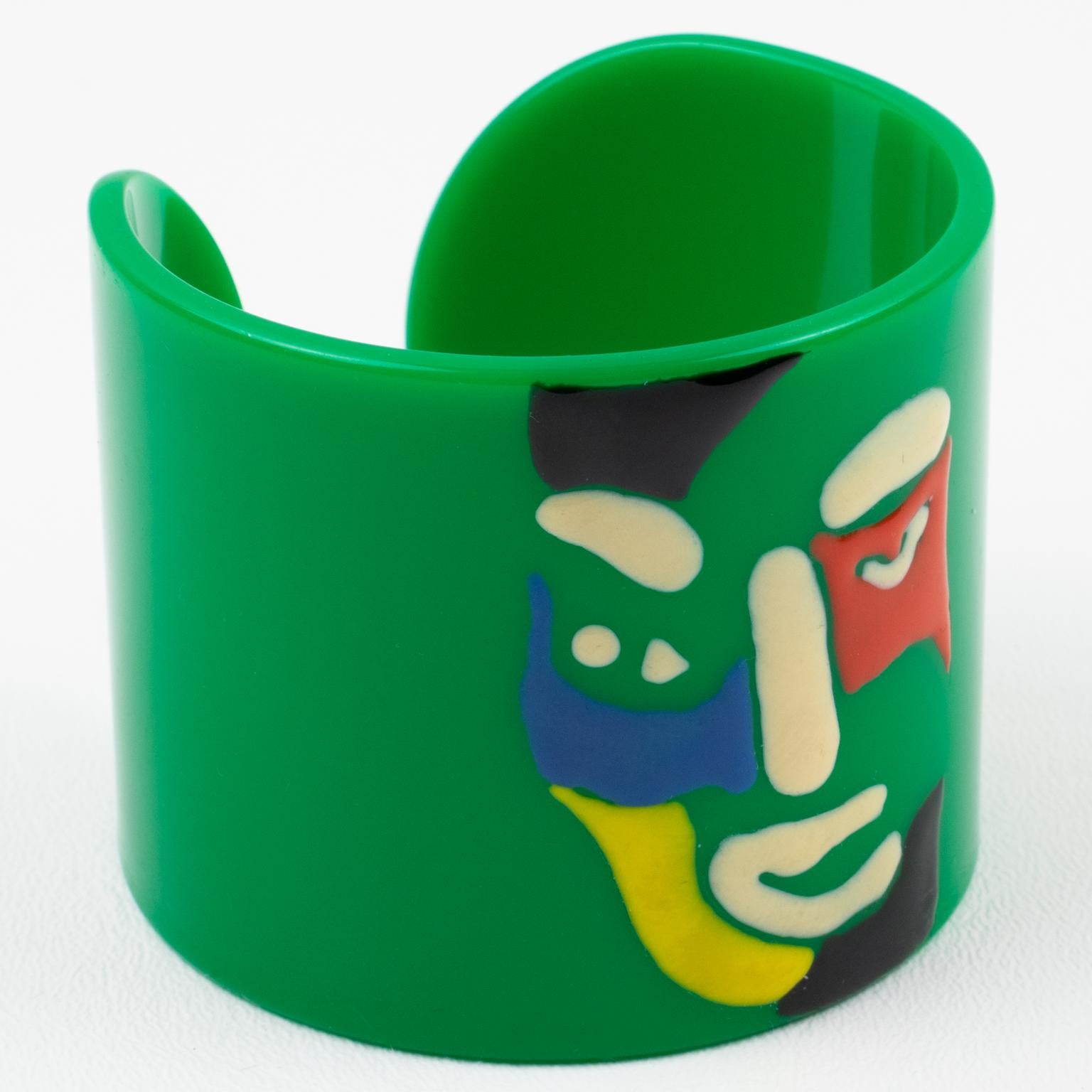 A rare iconic Missoni, Italy cuff bracelet. This 1980s couture Italian designer, Rosita Missoni bracelet is adorned with a multi-color iconic smiling face. Emerald green resin background with the hand-enameled multicolor smiling face. No visible