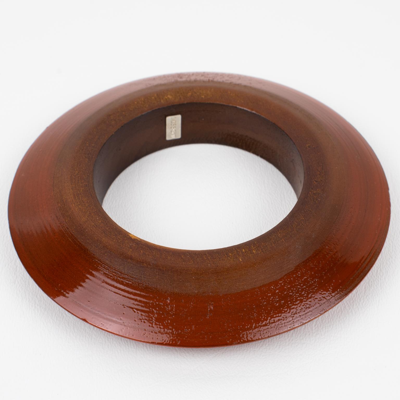 A stunning Missoni, Italy, ethnic-inspired wooden bracelet. A massive flying saucer shape bracelet made of tropical wood with maroon enamel paint application. 
The marking is inside the bracelet with a small metal brand logo indicating