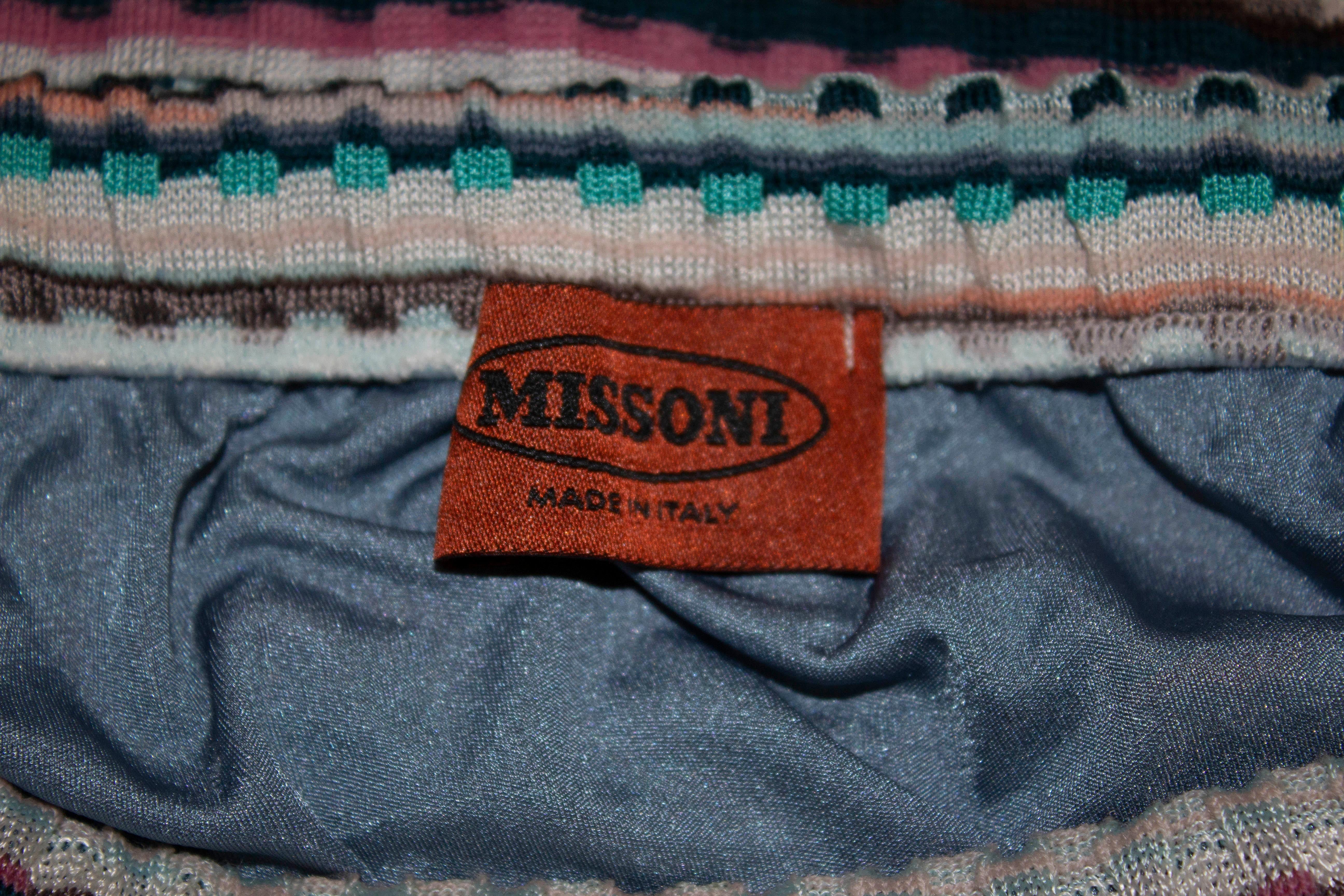 Une jolie jupe courte pour l'été par Missoni.  Dans un mélange de couleurs turquoise, grises et roses, la jupe présente un joli motif tricoté et est entièrement doublée. 
Il a une taille élastiquée et s'adapte à une taille de 25'' - 29'', longueur