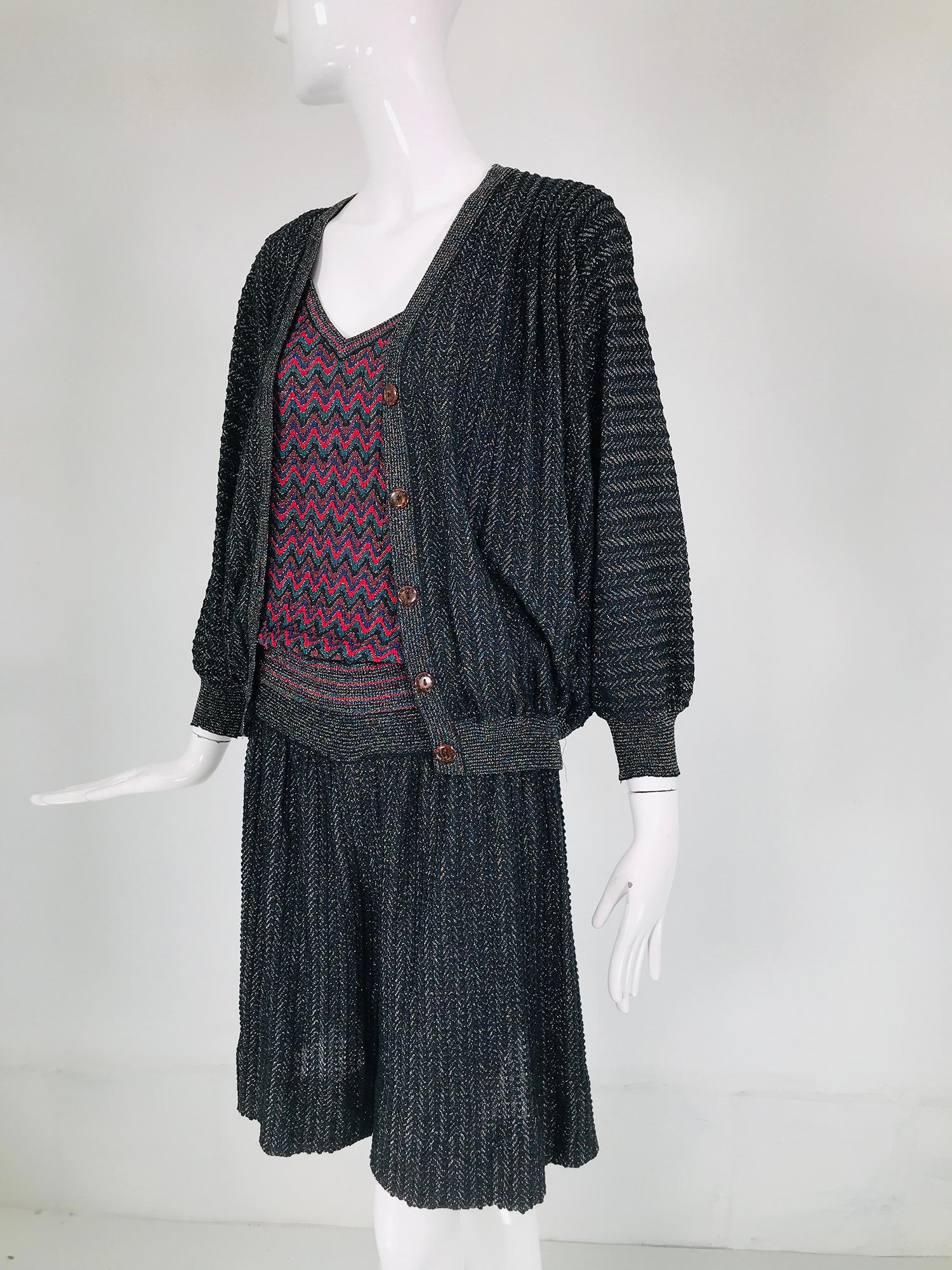Vintage Missoni metallic knit 3pc culotte skirt set from the 1980s. Charcoal grey with silver metallic thread cardigan sweater that has bat wing sleeves, gathered shoulders & ribbed cuffs & hem. The sweater closes at the front with amber colour