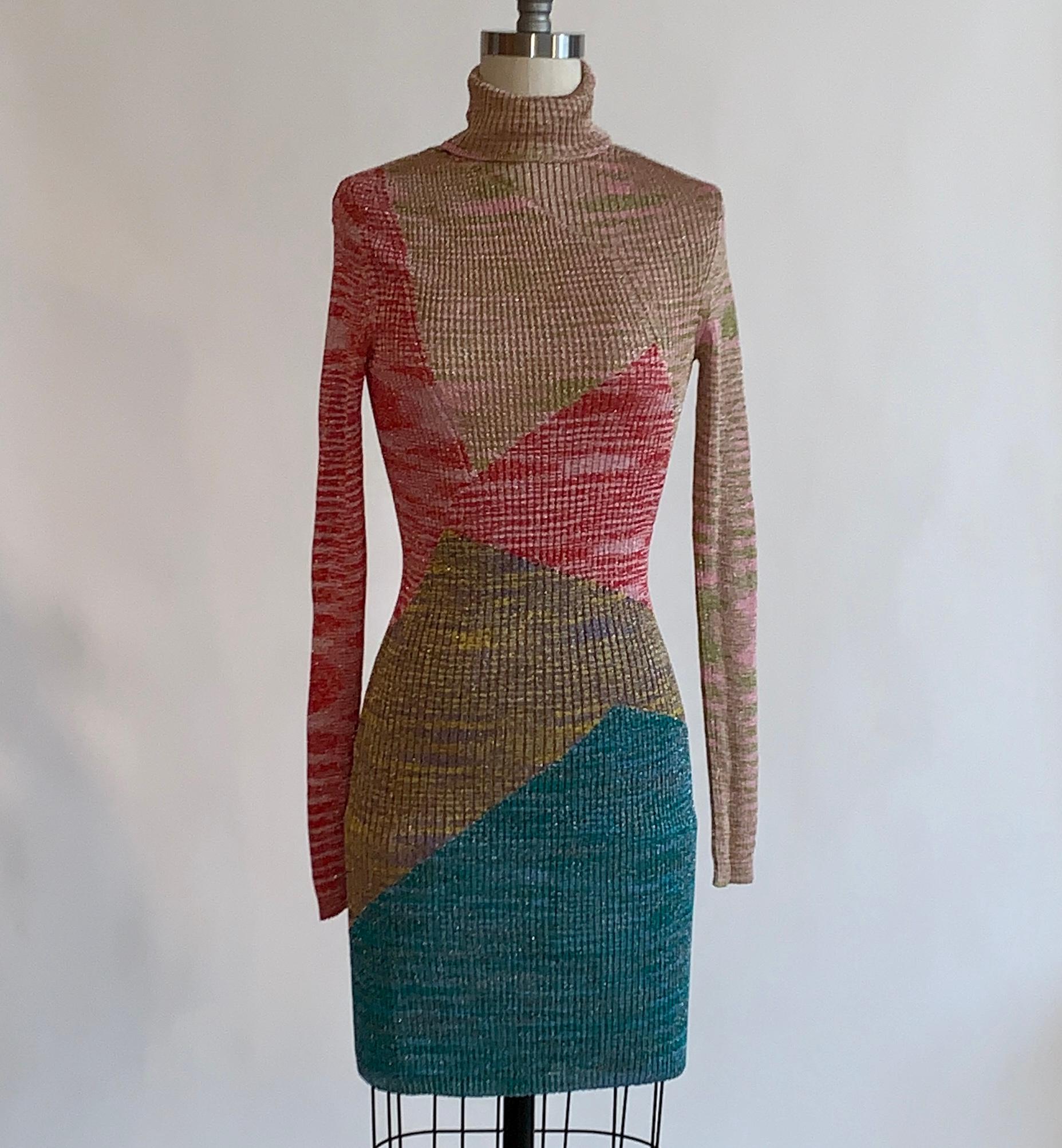 Missoni long sleeved geometric knit dress in metallic pink, orange, lavender,  gold, and blue. Ribbed knit with turtleneck and long sleeves. Pulls on. A very slight sheerness to the fabric, you may want to add a slip beneath. 

64% viscose, 23%