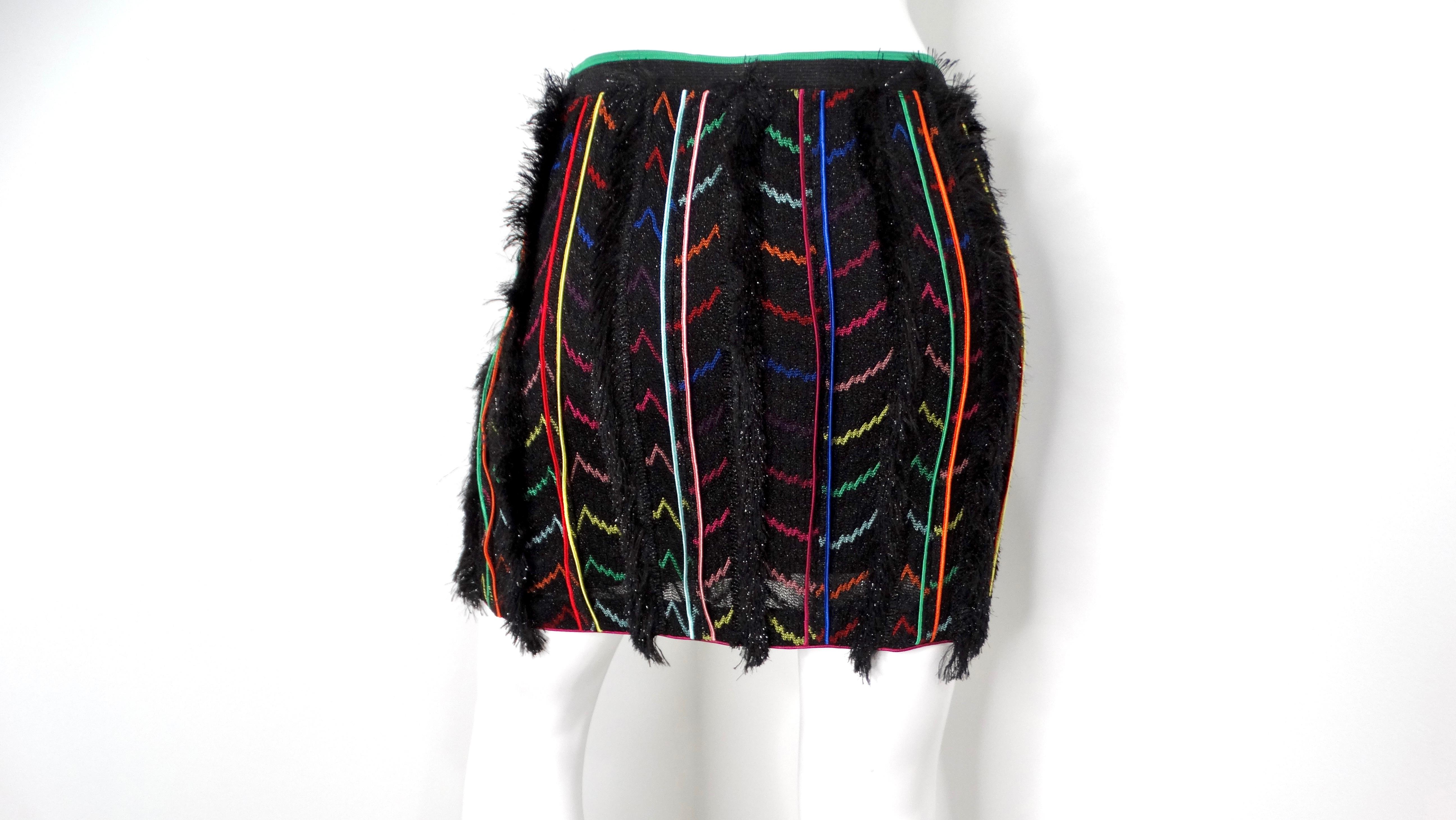 Embrace bold colors and playful patterns with the Missoni Multicolor Stripe Knit Fringe Mini Skirt. This eye-catching piece features a striking black base adorned with vibrant stripes and zig-zag motifs, exuding the quintessential Missoni aesthetic.
