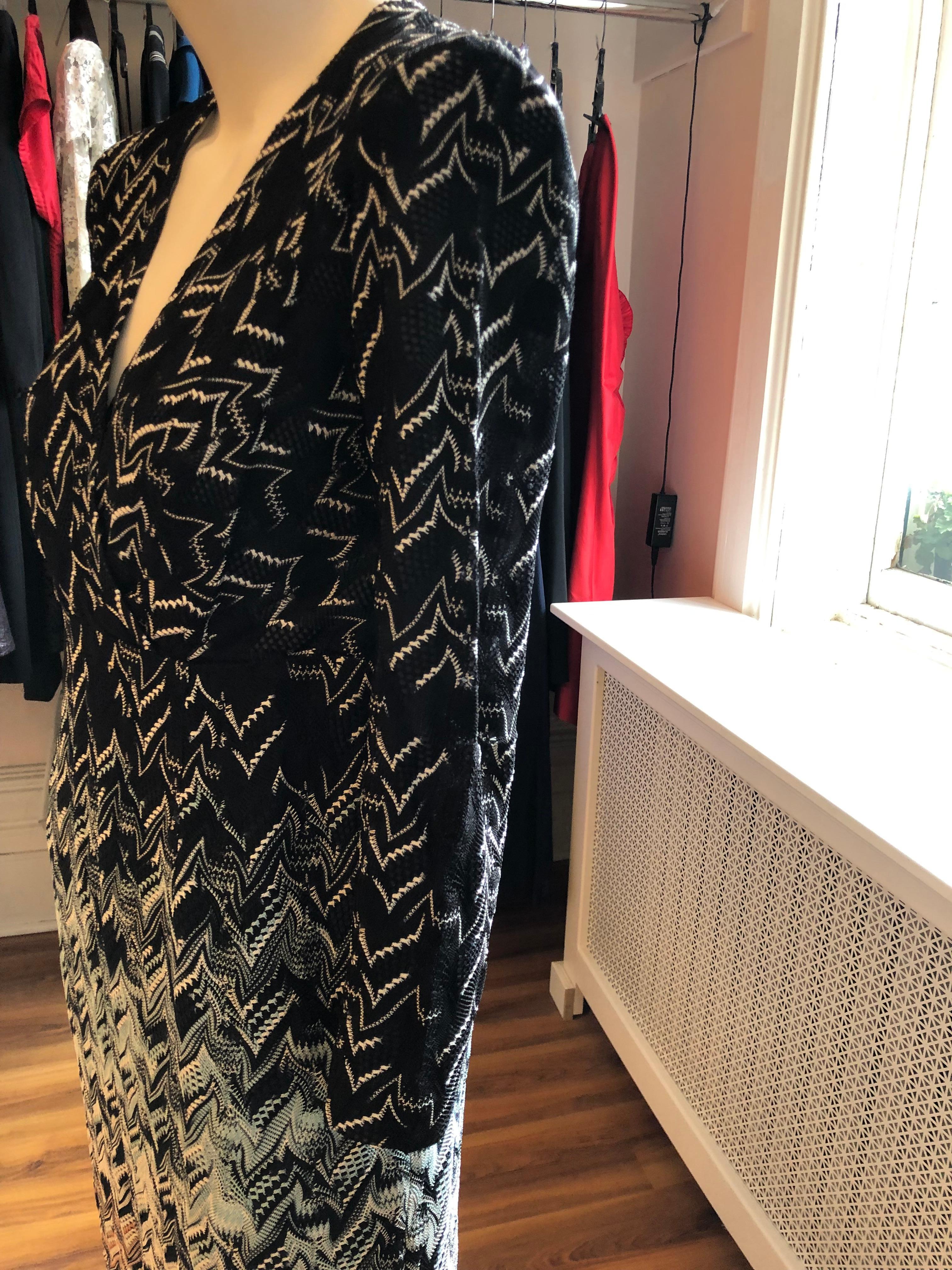 This dress has an unusual abstract zig zag pattern with an ombre graded look.  Black and white at the top with aqua, orange, black and white at the bottom. The neckline is v-shaped and closure is by a zipper on the side. Easy to wear day or evening!
