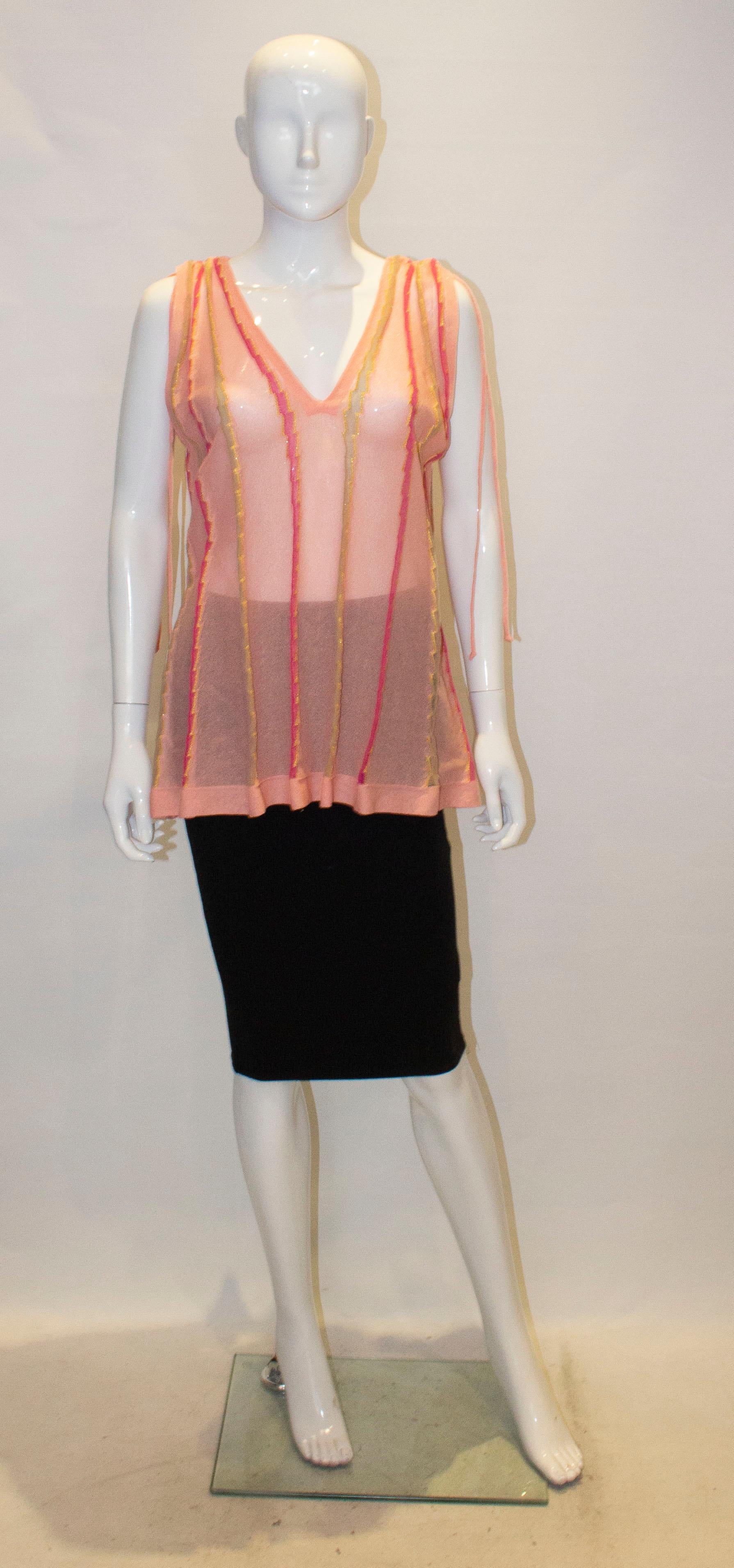 A pretty top for Summer from Missoni. The top is  salmon pink colour with gold and shoking pink vertical lines of decoration.It has a v neckline and backline with gathering on the shoulders.