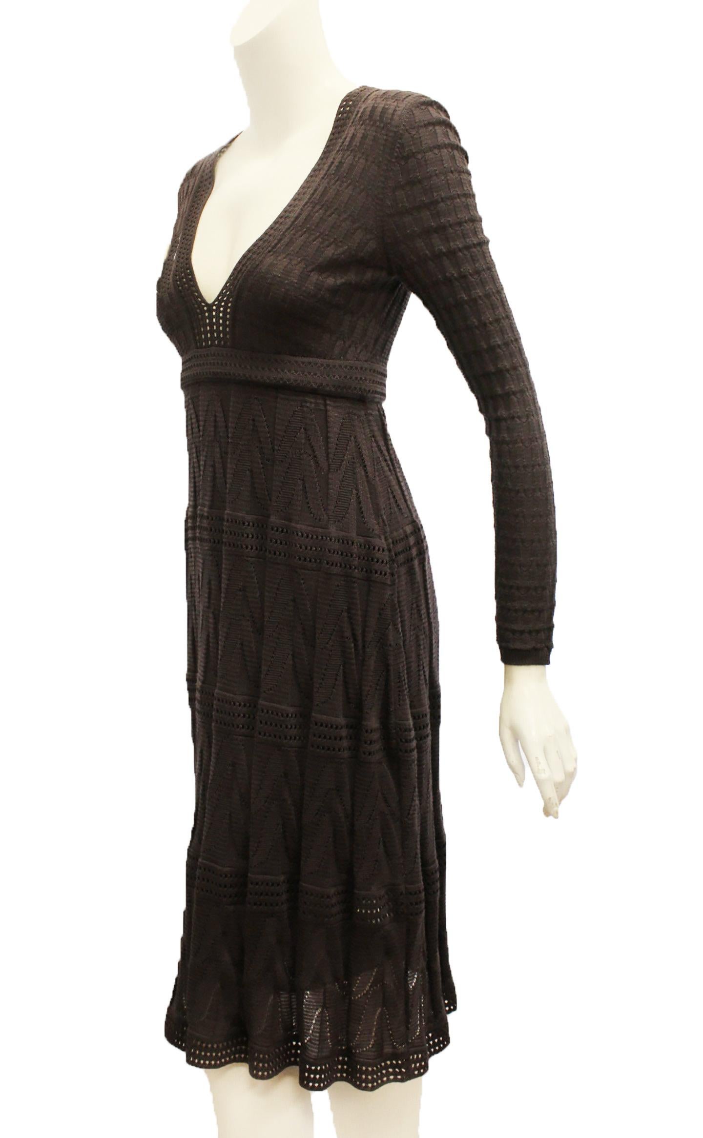 Missoni plum color dress with plunging V neckline crafted with wool and designed to show just a hint of skin, you'll love it for day to evening finesse.  The long sleeves are ribbed.  The trim on the V neck, around waist and on the skirt are open