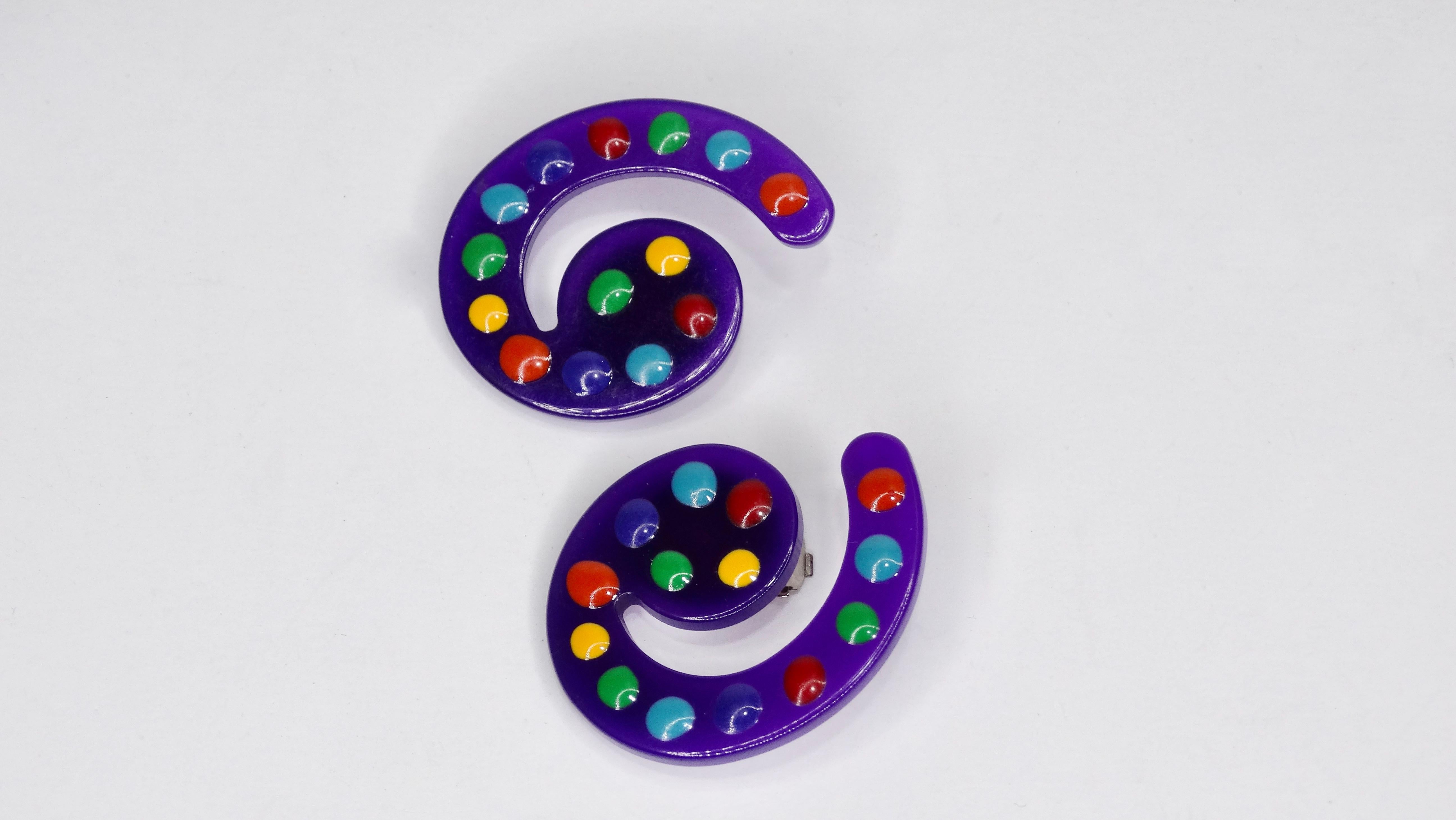 Bringen Sie etwas Farbe in Ihren Look mit unseren 1980er Missoni Clip On Ohrringen! Diese Ohrringe sind aus violetten Lucit-Spiralen gefertigt und mit bunten Punkten verziert. Rückseiten zum Aufstecken. Missoni-Etiketten auf den Rückseiten.

Höhe:
