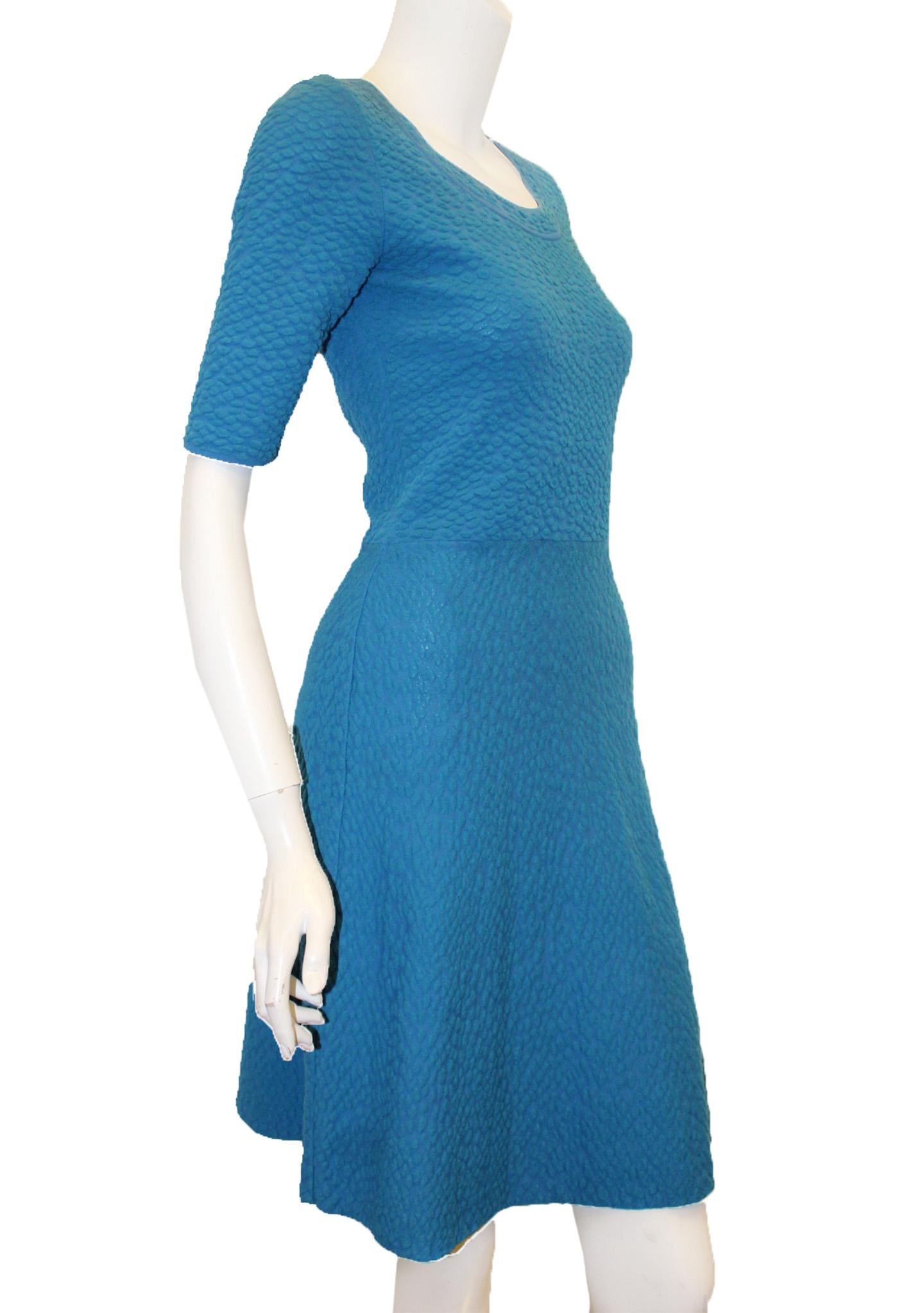 Missoni textured turquoise short sleeve knit dress with round collar is not lined and is the ideal summer dress that can transition to the fall by adding a light coat or a cardigan.  This dress has minor pulls, otherwise, it is in good condition.   