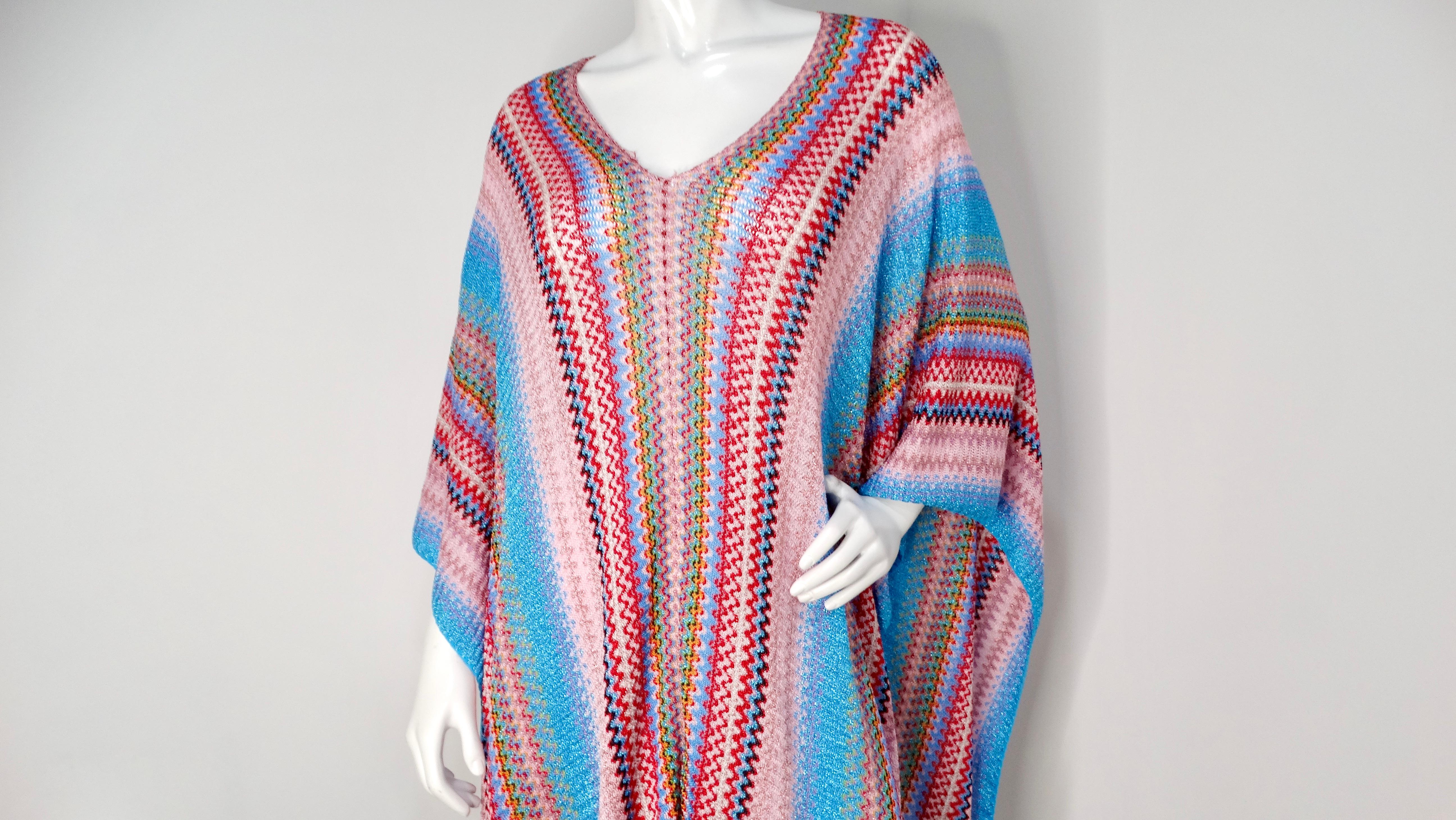 The Missoni Zig Zag Multicolor Knit Poncho is a striking piece that effortlessly embodies the vibrant essence of the iconic Italian brand. Crafted with a classic zig-zag pattern that features an eye-catching blend of blues, pinks, reds, and