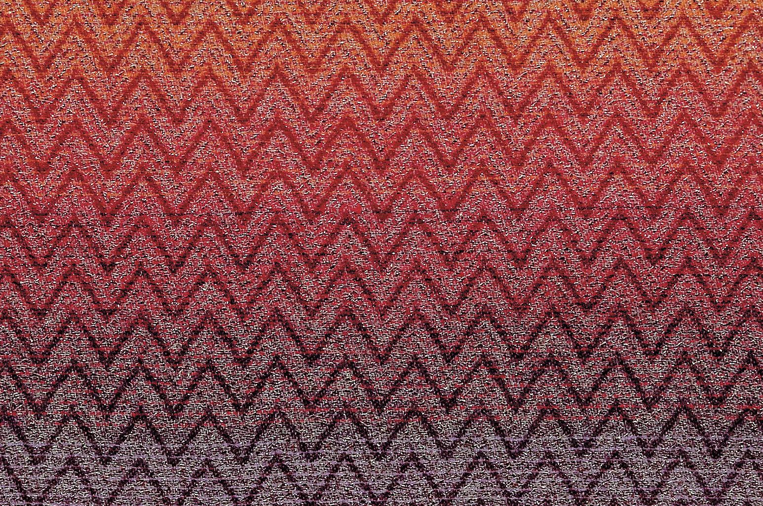 Throw in shaded wool blend with lurex applications and iconic Missoni geometric chevron print. Throw in warm shades of red, purple and blue with neutral tone fringe trim. Presented in a branded gift box. Perfect for adding an elegant touch to any