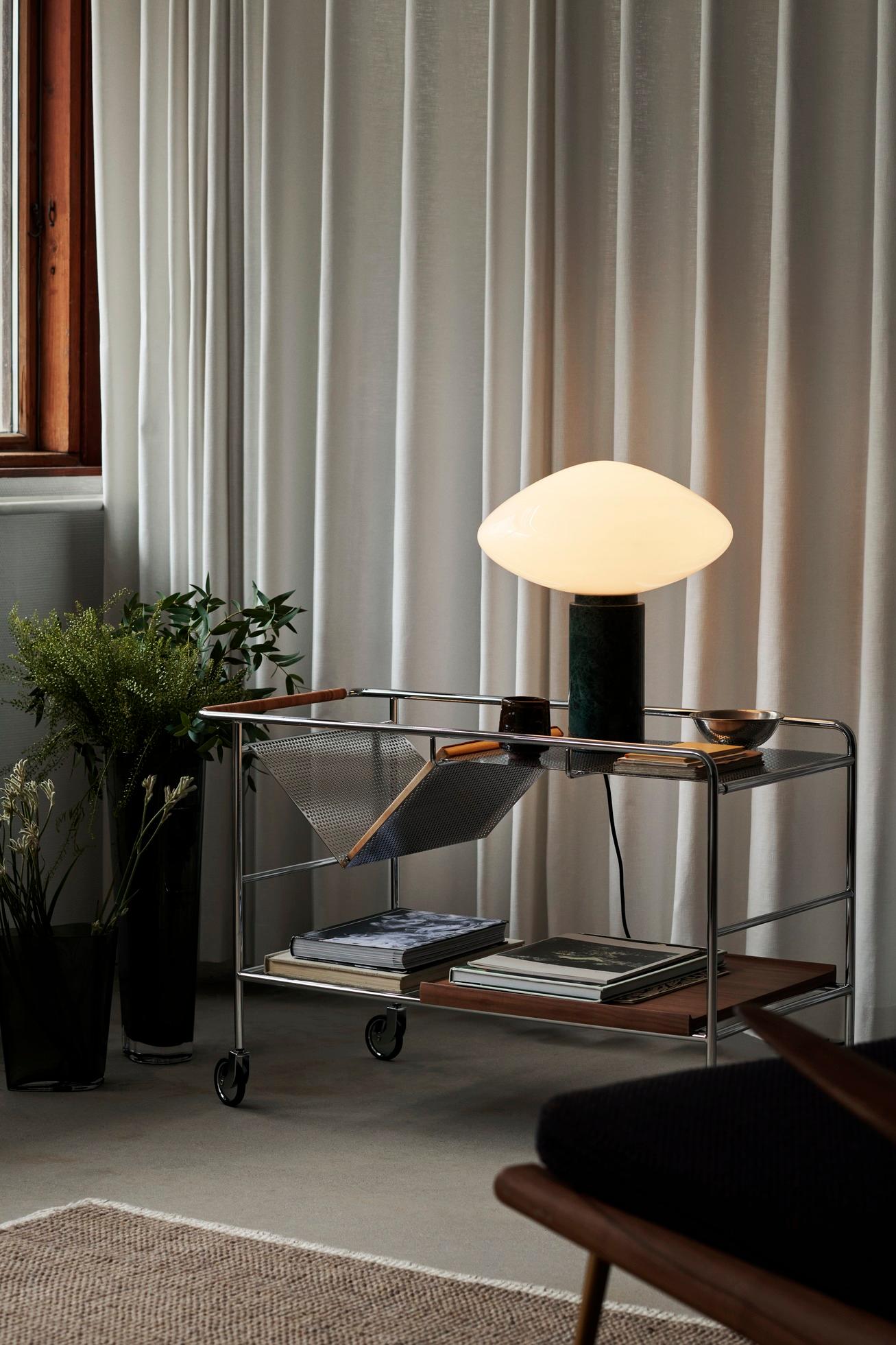 The Mist table lamp, made from mouth-blown opal glass, features a thick marble pillar with a small dimmer switch. The contrast between the light shape of the glass and the solidity of the marble creates an elegant design rich in materiality.

Color
