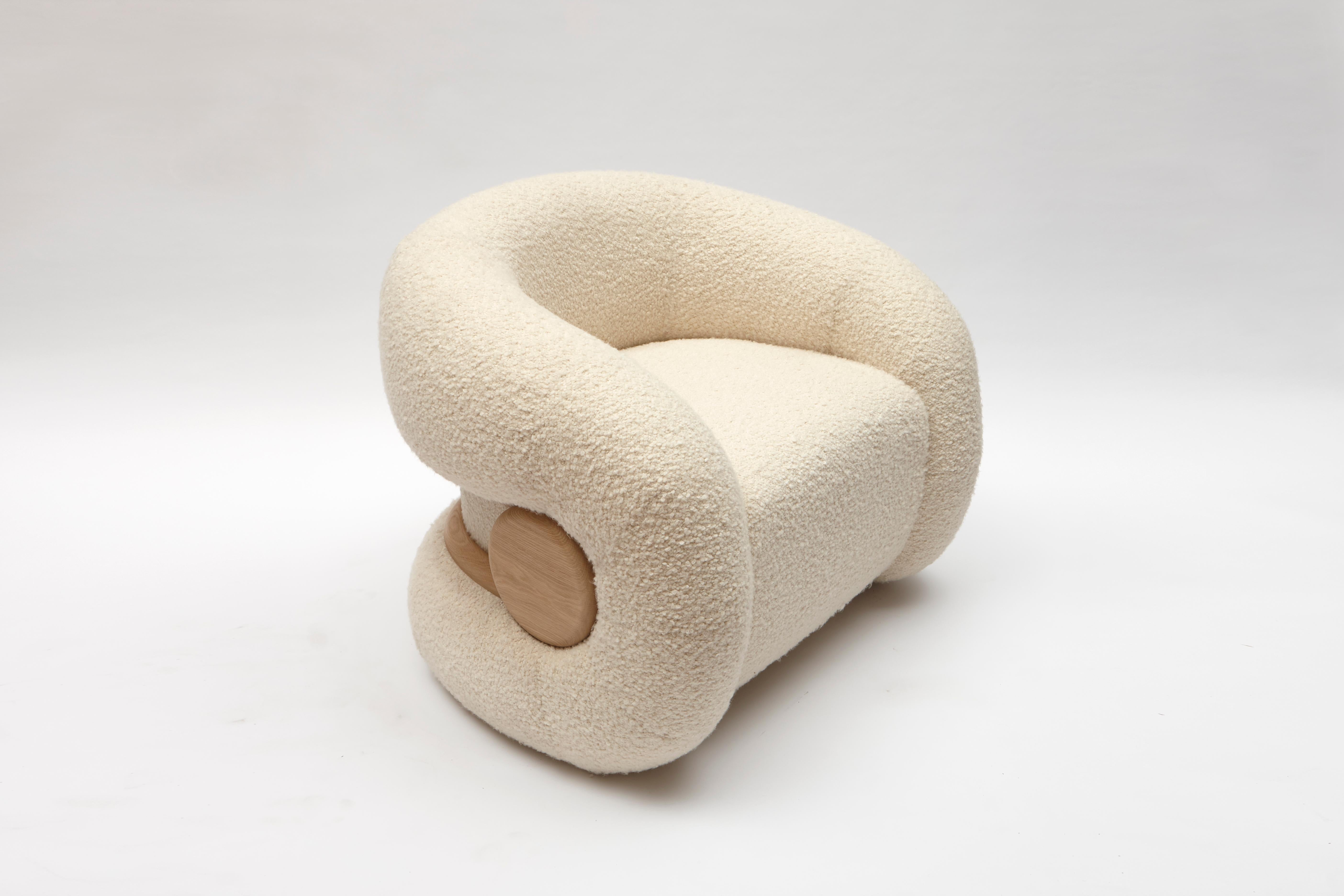 Mistral-Sessel von Studio Bazazo
Abmessungen: T 80 x B 100 x H 78 cm. 
MATERIALIEN: Bouclé-Stoff und französische Eiche.

Leicht wie eine Brise und mit der Kraft, Landschaften zu formen, ist die Kollektion 