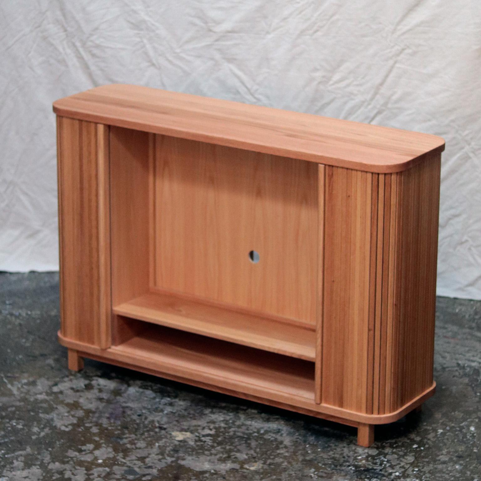 The Mistry cabinet is entirely crafted by hand.  The tambour doors are entirely exposed, covering the interior storage cabinet.  The interior fit out is entirely customizable.  Customers can also specify dimensions and wood species.  

This cabinet