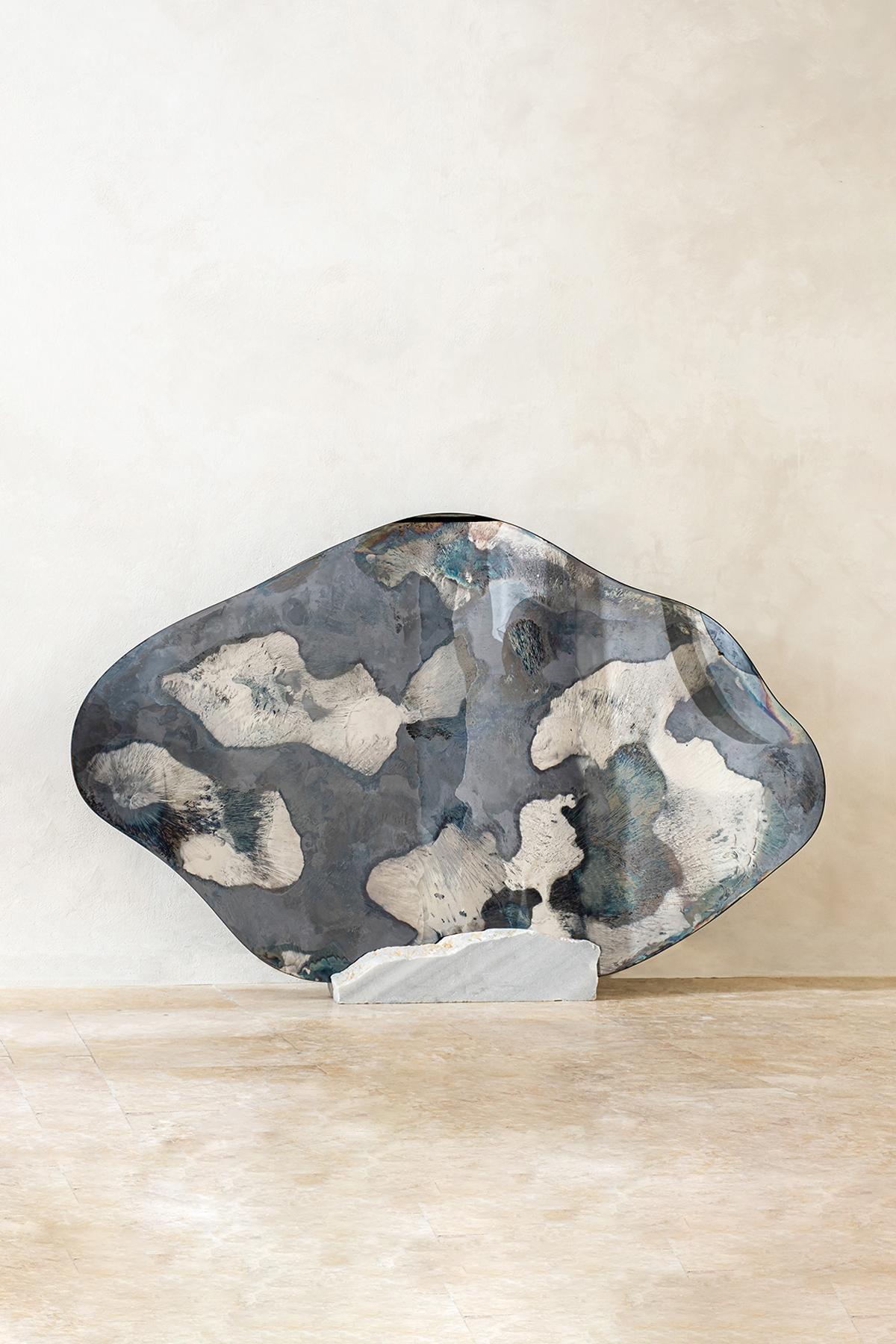Escultura Nube de Niebla de Homa
Dimensiones: An 150 x Pr 90 x Al 0,4 cm
Materiales: Espejo ahumado y plateado oxidado. 

HOMA es un taller de diseño contemporáneo con sede en Estambul. Los procesos característicos del Atelier A son el vidrio