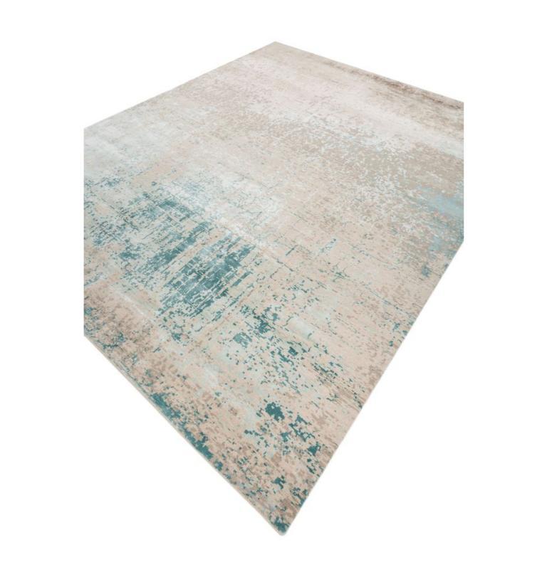 Stunning hand knotted rug featuring a gorgeous flowy pattern in soothing hues, where antique white gracefully merges with light sea mist tones, creating a sophisticated ambiance. The contemporary design showcases a harmonious interplay of flowy