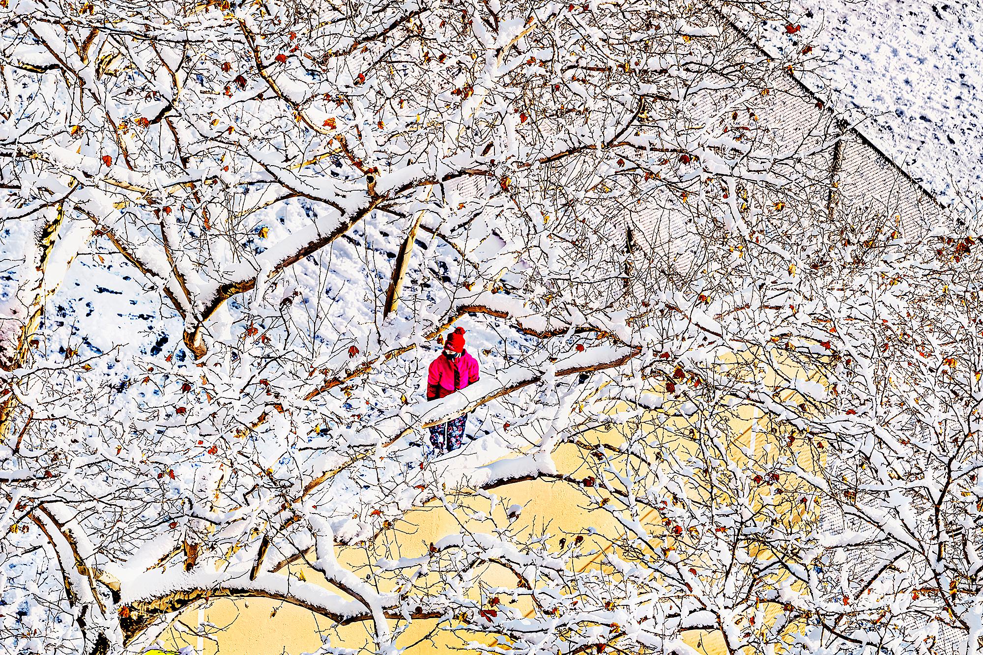 Eine abstrakte Winterszene mit einer einzelnen Figur in einem roten Mantel