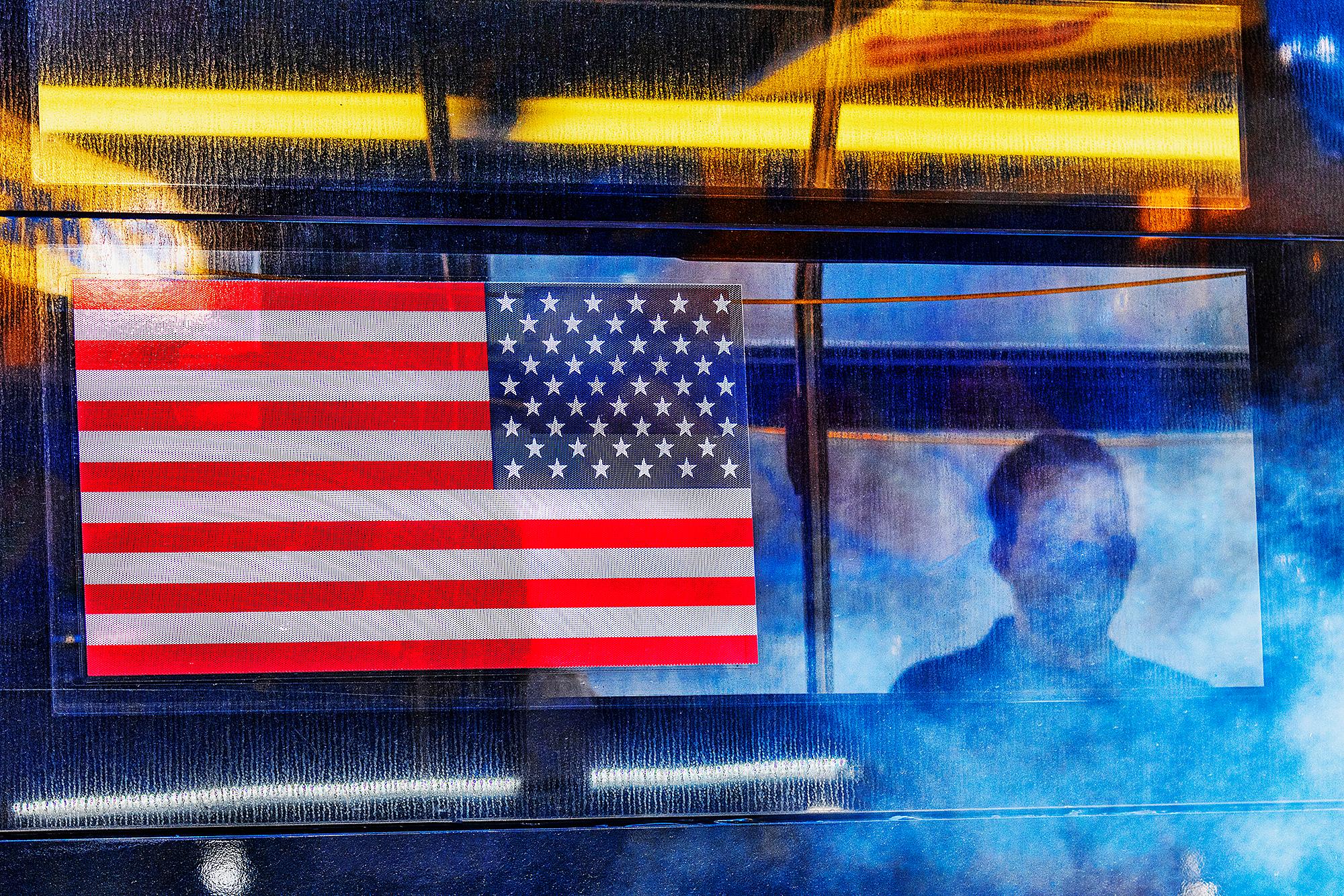 Color Photograph de Mitchell Funk - Bandera estadounidense en un autobús de Nueva York  - Abstracción del arte callejero de Moody.
