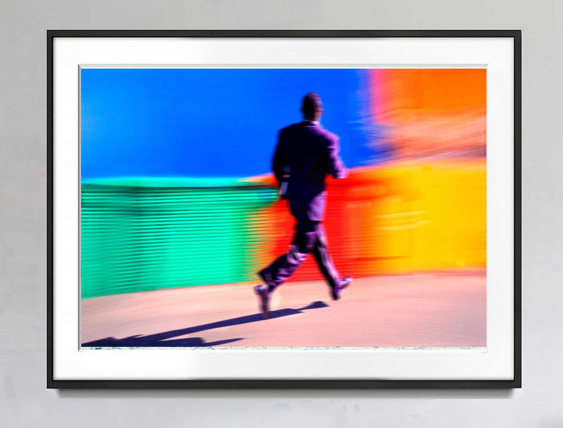 Black Businessman Running Against a Colorful Background - Photograph by Mitchell Funk