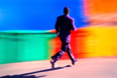 Uomo d'affari nero che corre su uno sfondo colorato