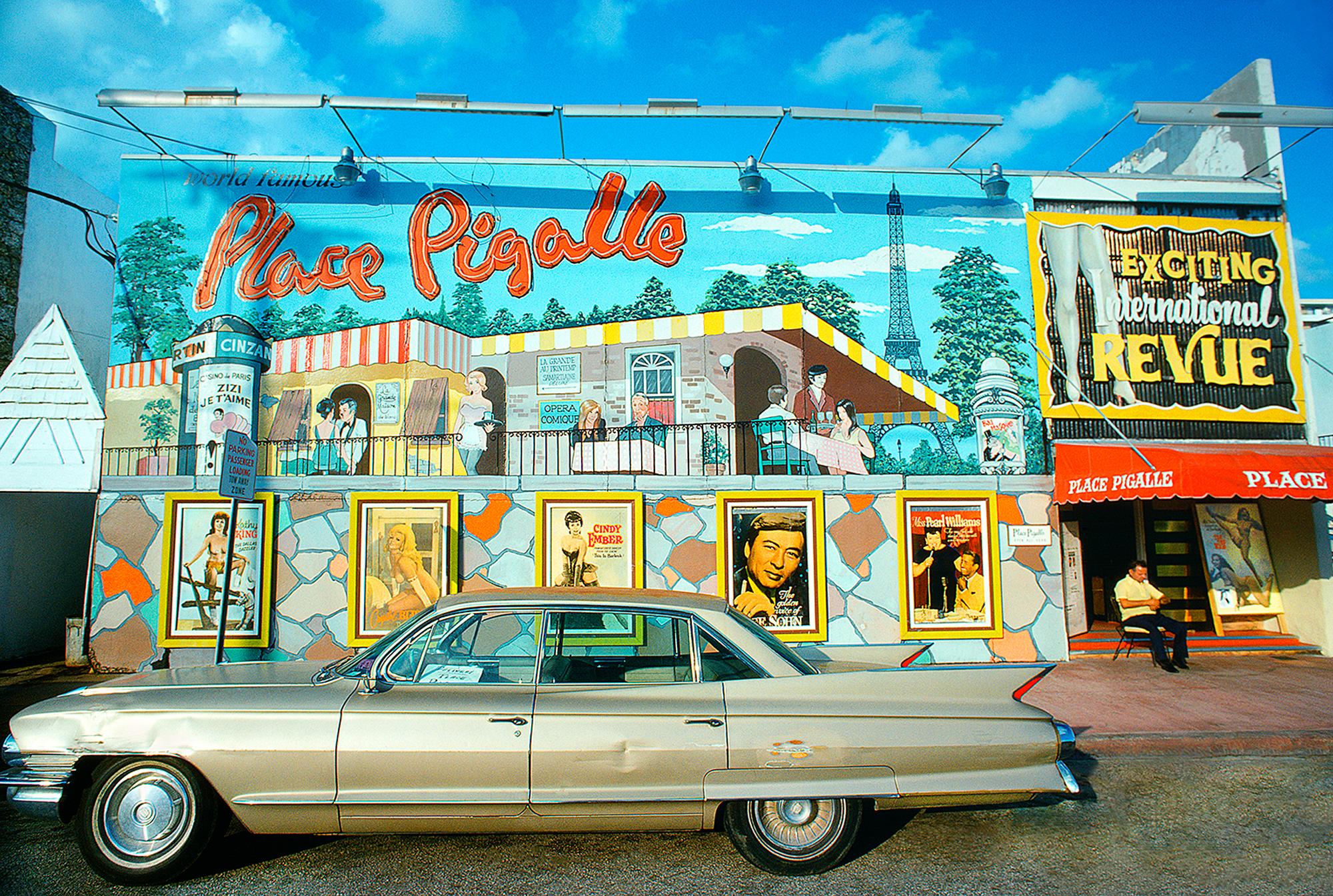 Espectáculo de Burlesque en la fachada de Miami Beach con coche de época, Kathy King, Cindy Ember  titular en la Exciting International Revue, Collins Avenue, Miami,  1974.   Así se llamaba un club de striptease en 1974. 
Firmado y fechado abajo a