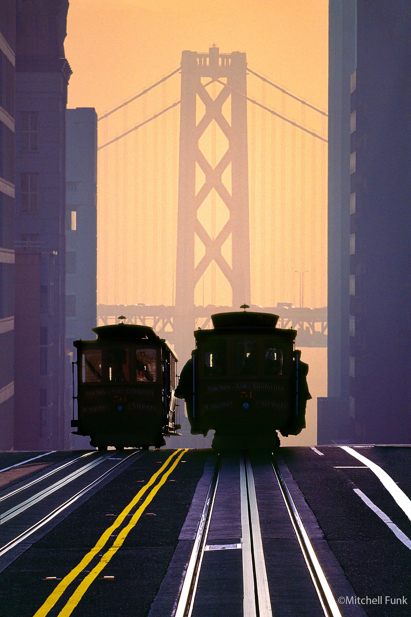Kabelwagen vor der Bay Bridge bei Sonnenaufgang in San Francisco