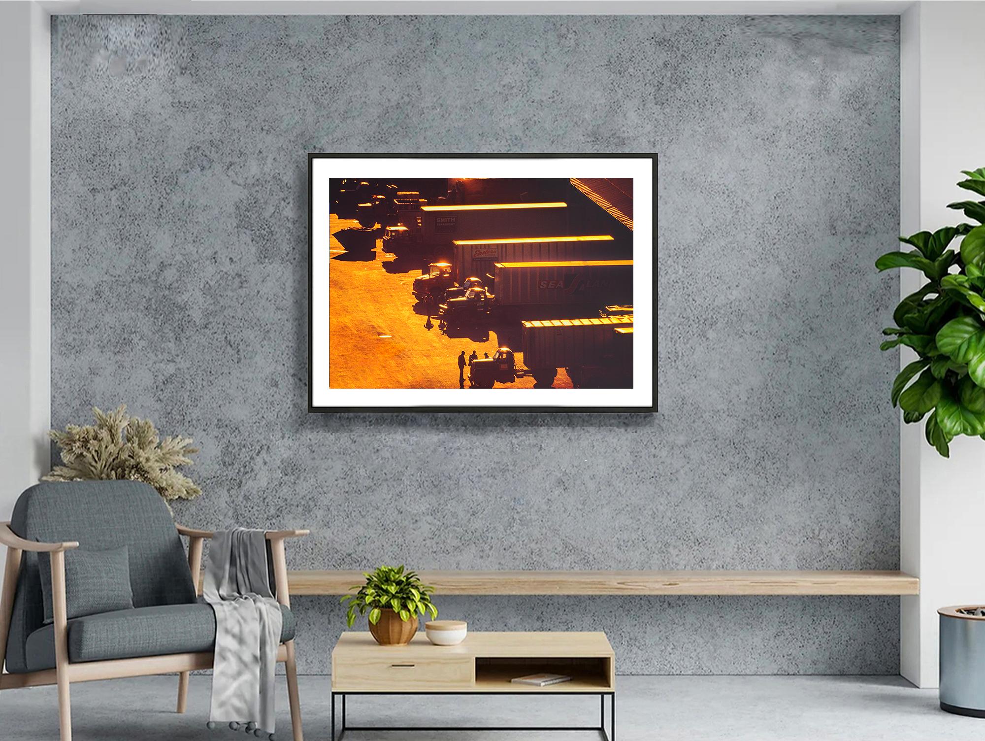 Old New York is captured. Angelic golden light caresses an industrial scene truck at a Chelsea West Side loading dock in 1972. The lighting transforms a gritty and oil-soiled space into something out of an impressionist painting. The image was taken