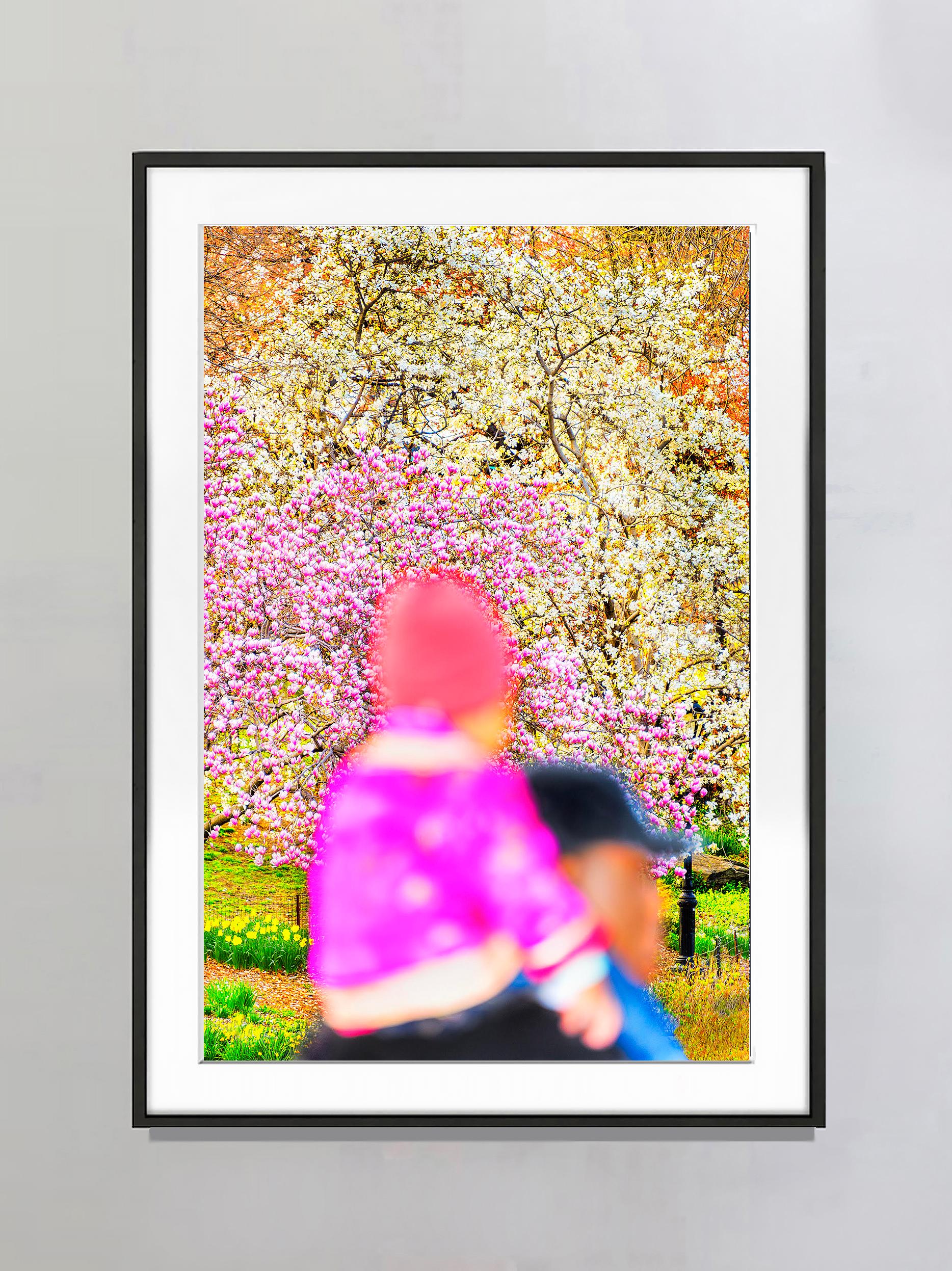 Child in Pink auf den Schultern eines Vaters gegen Kirschblüten – Photograph von Mitchell Funk