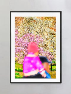 Child in Pink on Father's Shoulders Against Cherry Blossoms