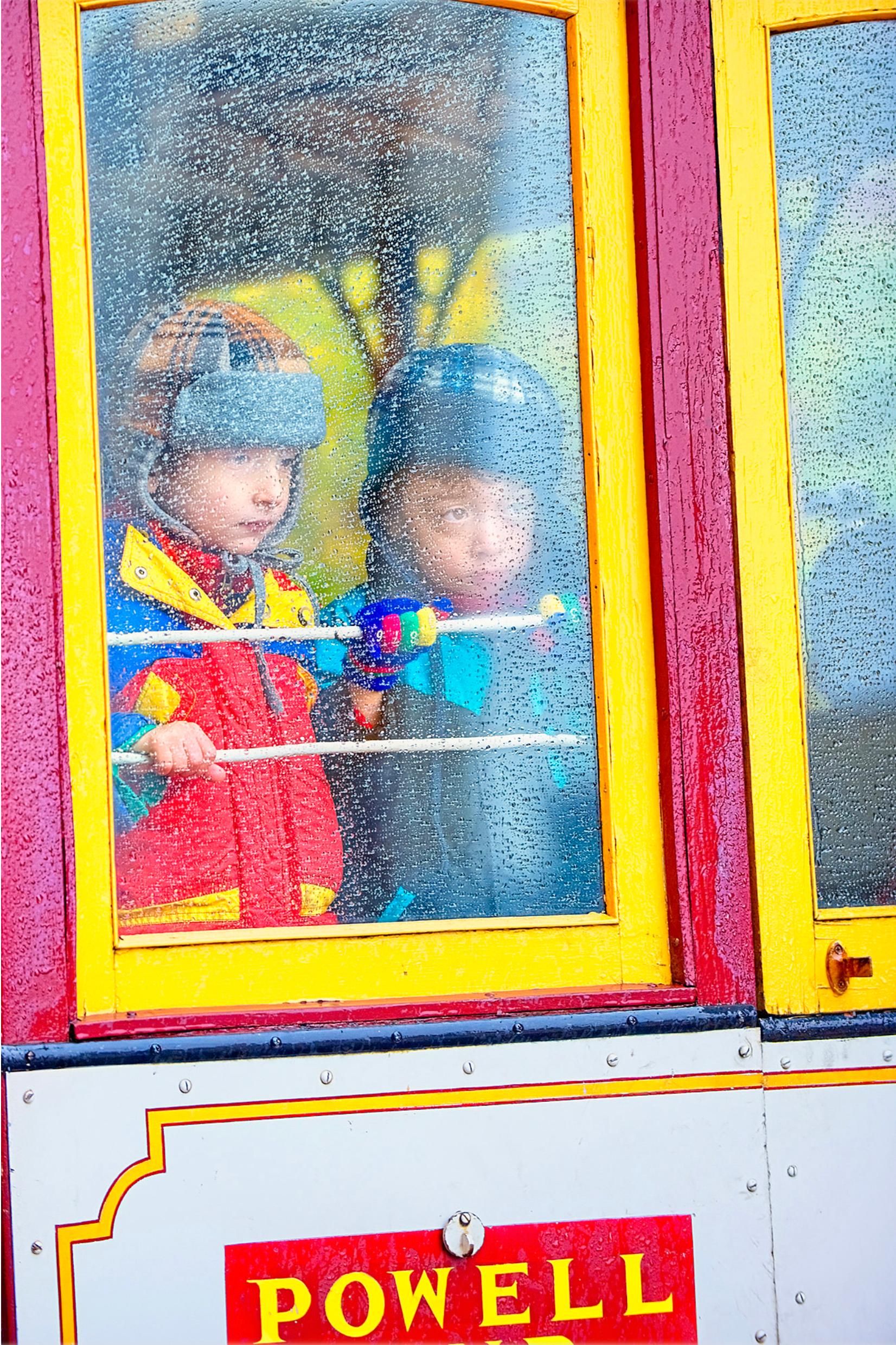 Bambini che guardano fuori dal tram di San Francisco sotto la pioggia, fotografia d'autore