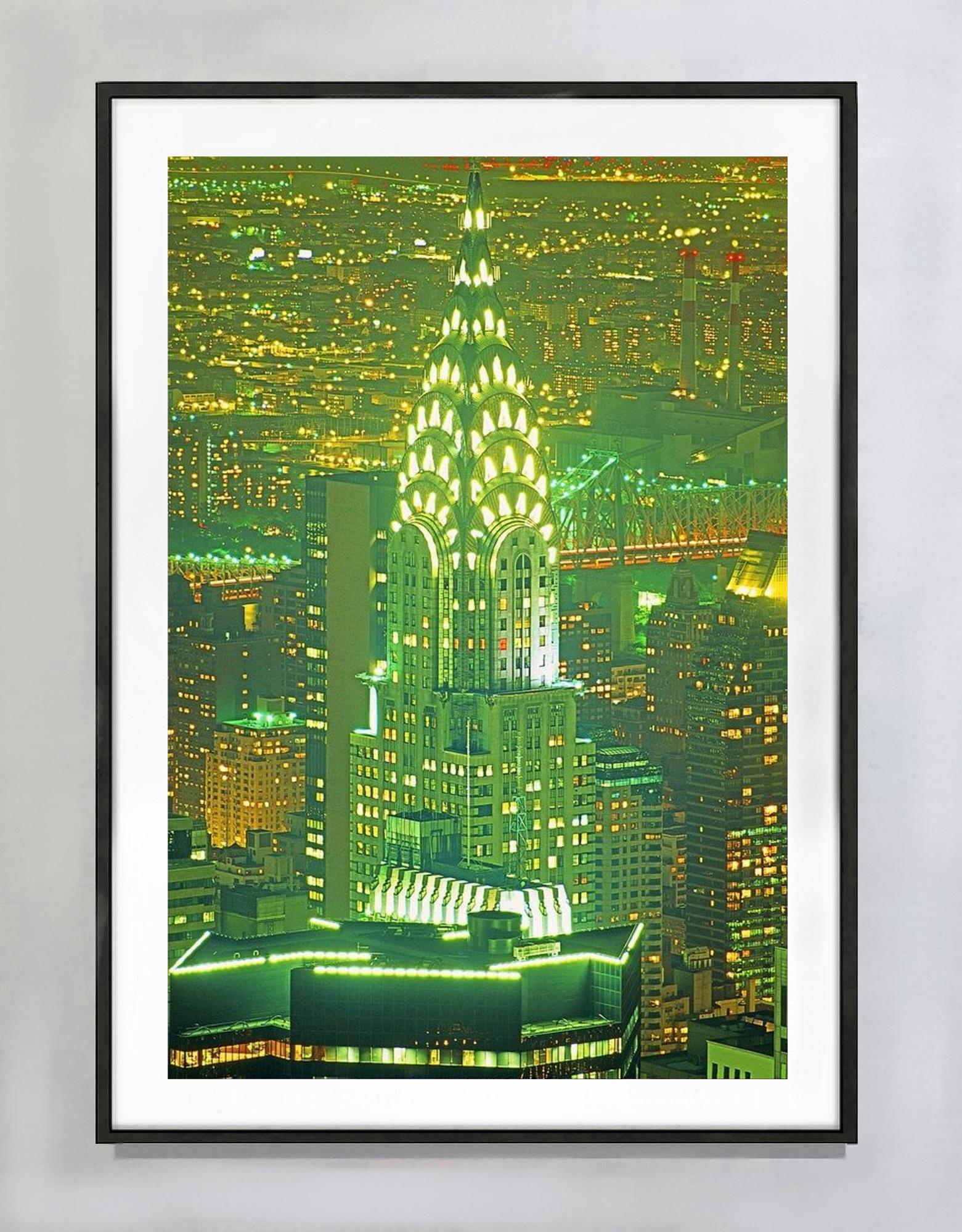 Il Chrysler Building si erge come un razzo in un cielo scintillante, trasmettendo un senso di illimitatezza. Un'aura di luce soffusa accarezza la scena, dandole un tocco di significato mistico. Si vede dall'osservatorio dell'Empire State Building,