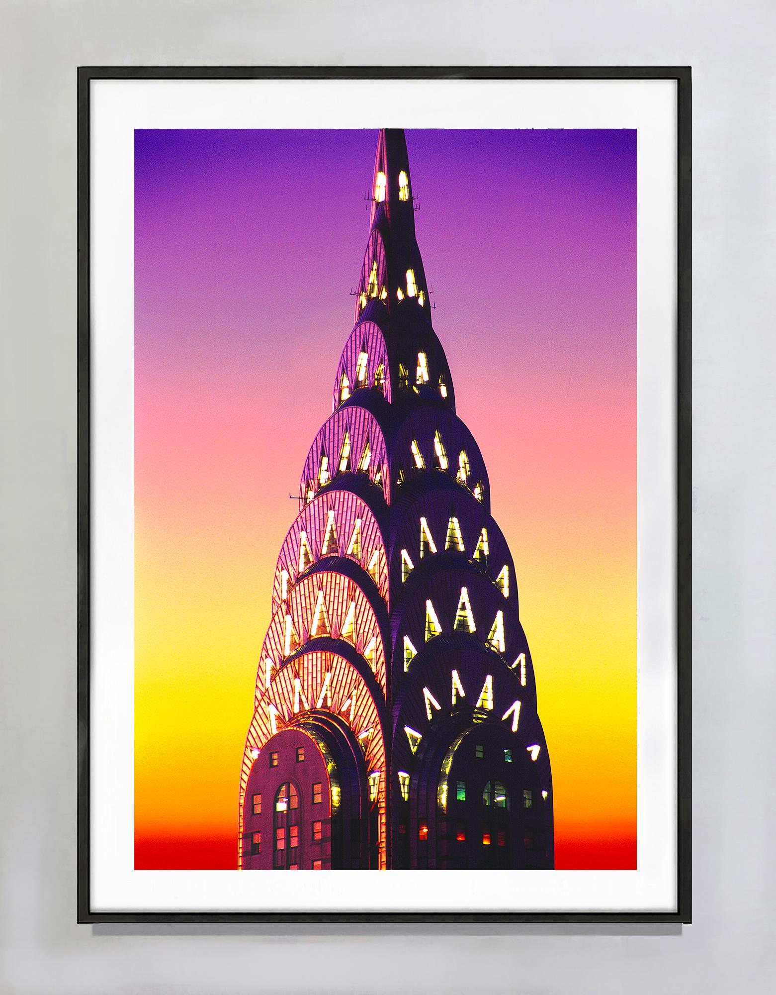Corona del Chrysler Building di notte con cielo luminoso - Photograph di Mitchell Funk