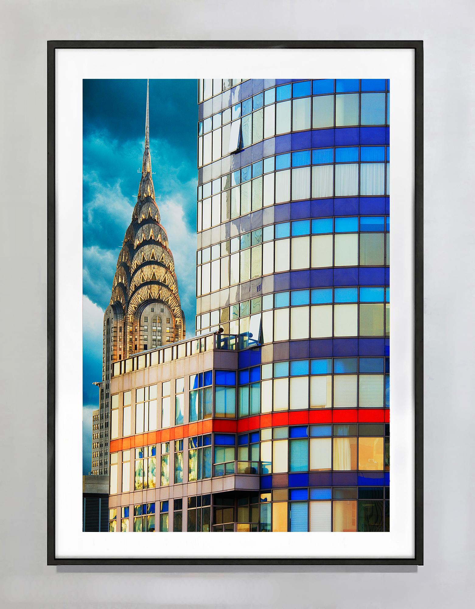 La guglia del Chrysler Building viene immortalata mentre spunta da dietro un grattacielo sulla Third Avenue a New York. È incorniciato perfettamente nel quadrante superiore sinistro del piano dell'immagine. Nel tardo pomeriggio, il sole illumina la
