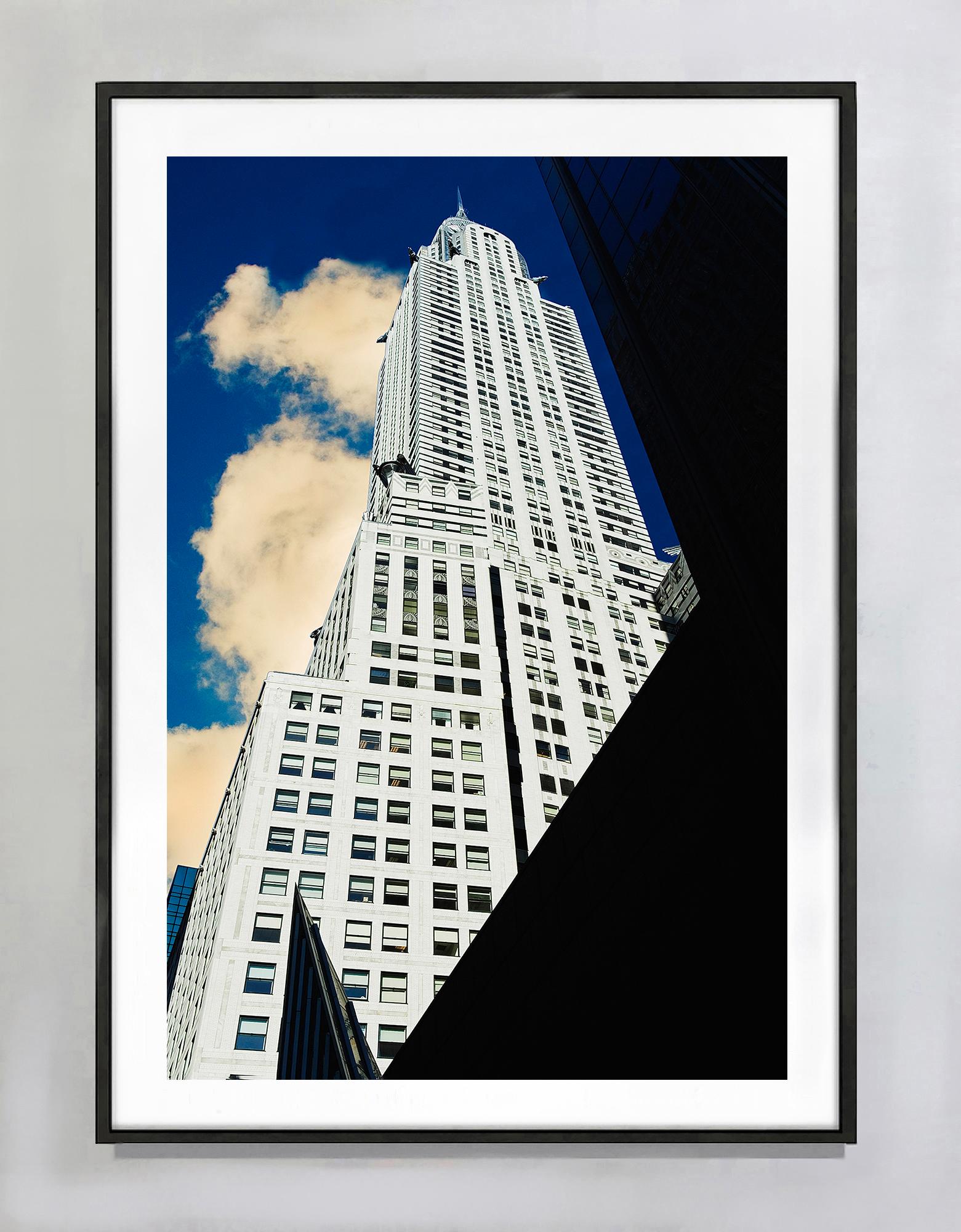 Das Spiel von Licht und Schatten kommt in dieser Fotografie von Mitchell Funk voll zur Geltung. Sein Blick von oben auf das Chrysler Building aus einem unerwarteten Winkel weicht von der traditionellen Farbfotografie ab, indem er  stellt die