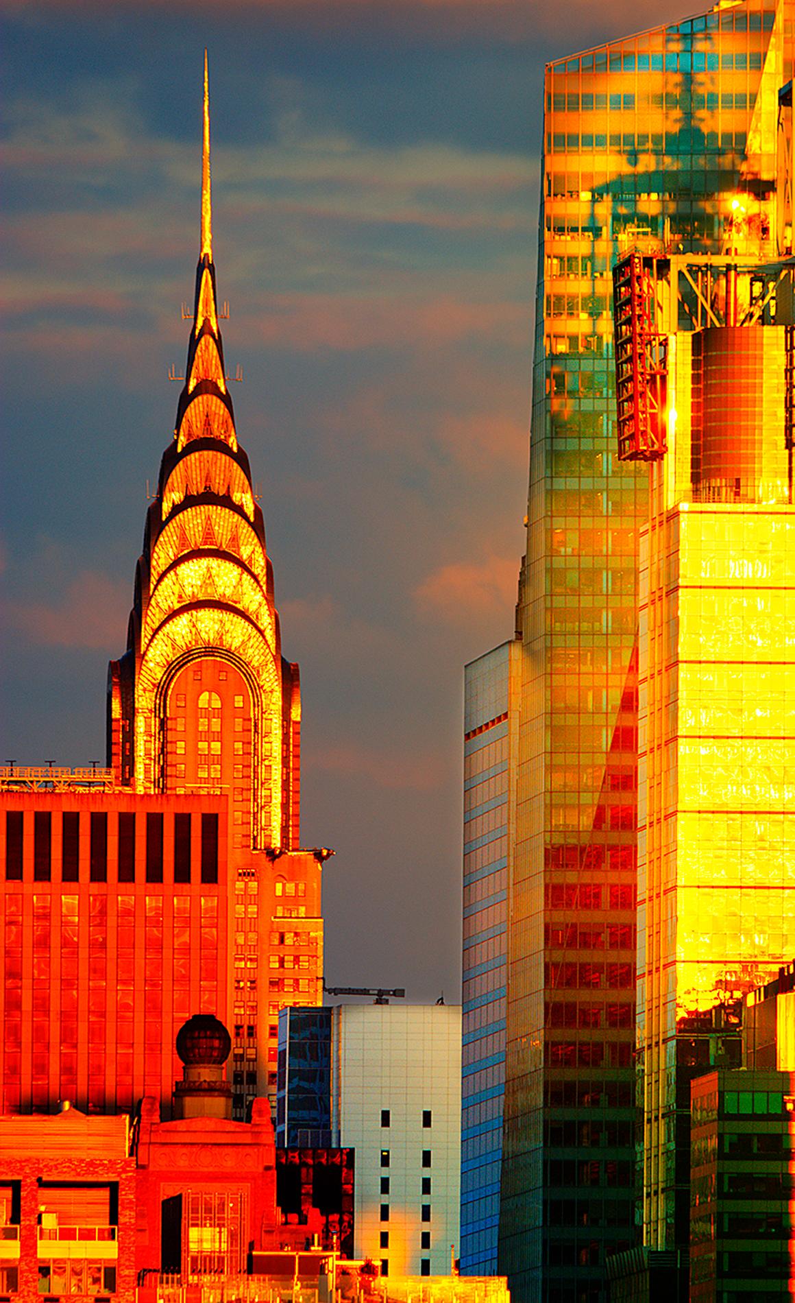 La guglia del Chrysler Building brilla di luce dorata,  Skyline di Manhattan - Photograph di Mitchell Funk