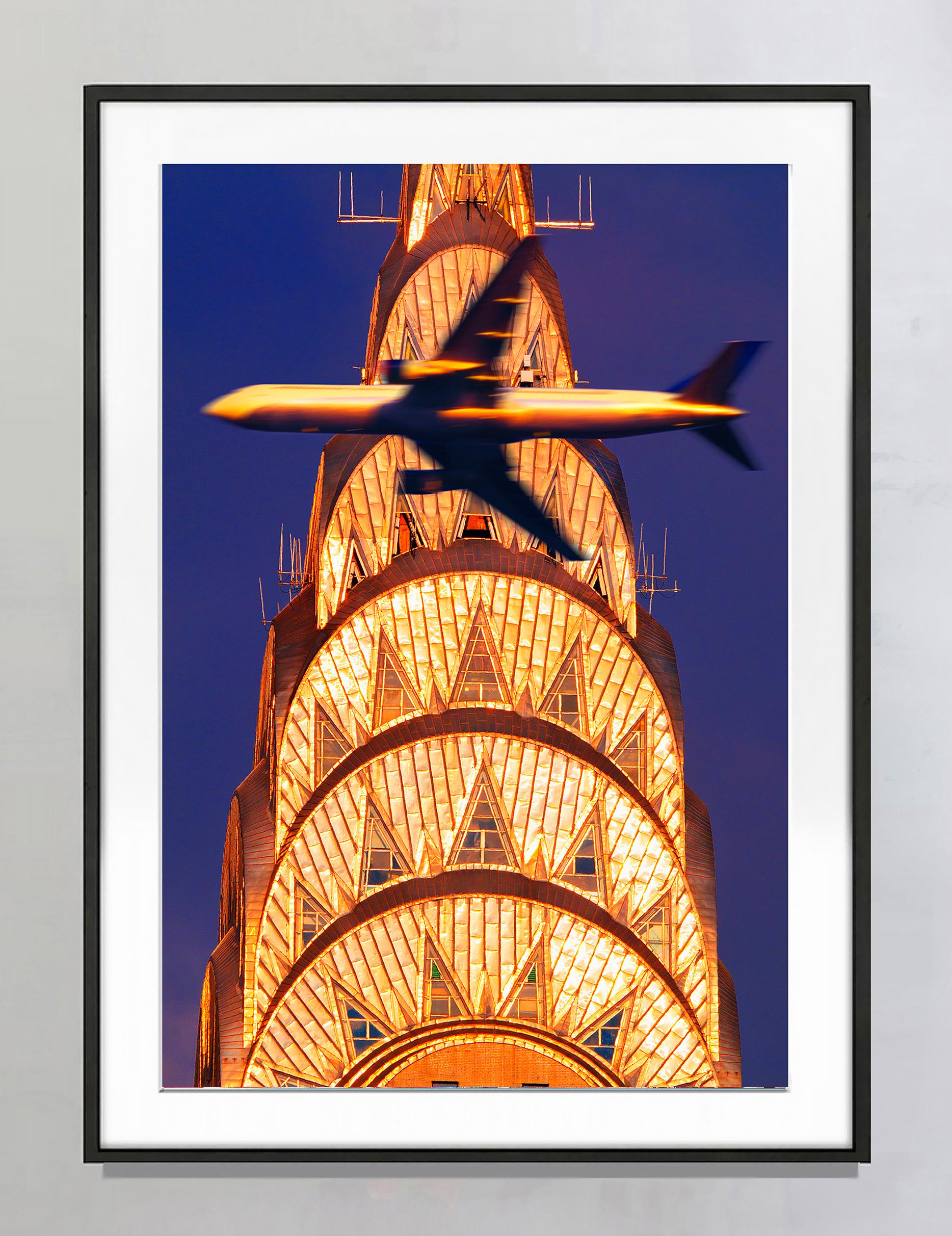 Chrysler Building Spire in Golden Light Intersected with Airplane,  Art Deco - Photograph by Mitchell Funk