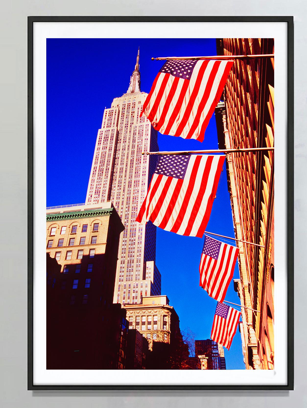 Empire State Building And American Flags, New York City - Photograph by Mitchell Funk