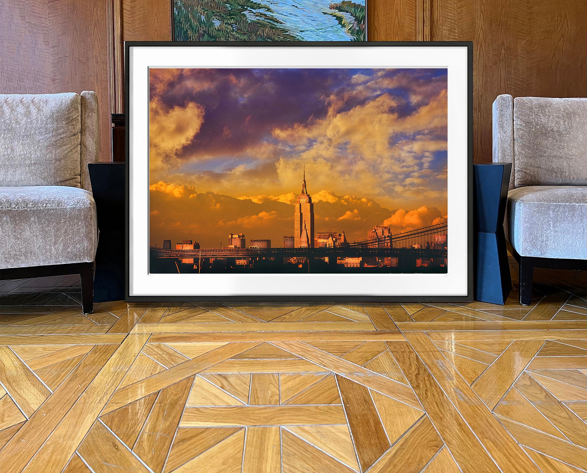 Das goldene Licht des späten Nachmittags taucht das majestätische Empire State Building in leuchtende Farben, während es den dramatischen Himmel durchdringt. Dieses Bild ist nicht nur atemberaubend in seiner visuellen Schönheit, sondern auch ein