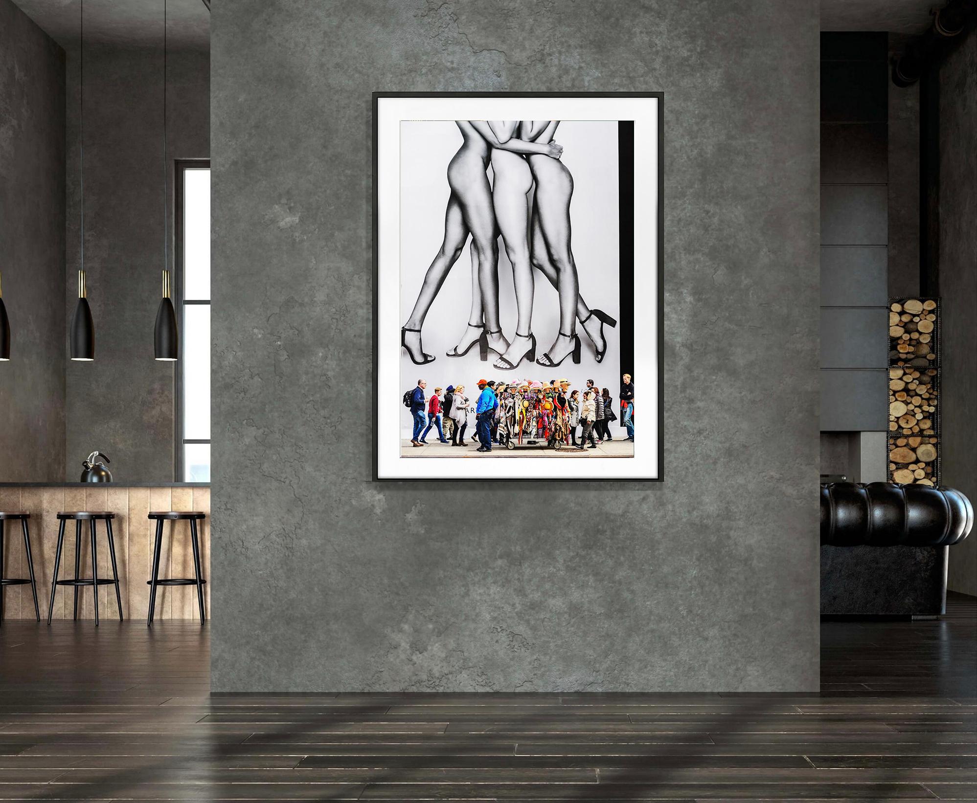 Eine monumentale Plakatwand auf der Fifth Avenue, auf der drei nackte, nur mit Schuhen bekleidete Models abgebildet sind, erhebt sich über die vorbeigehenden Fußgänger. Die Szene ist geprägt von einem tief beeindruckenden Bild der Beine.   Das