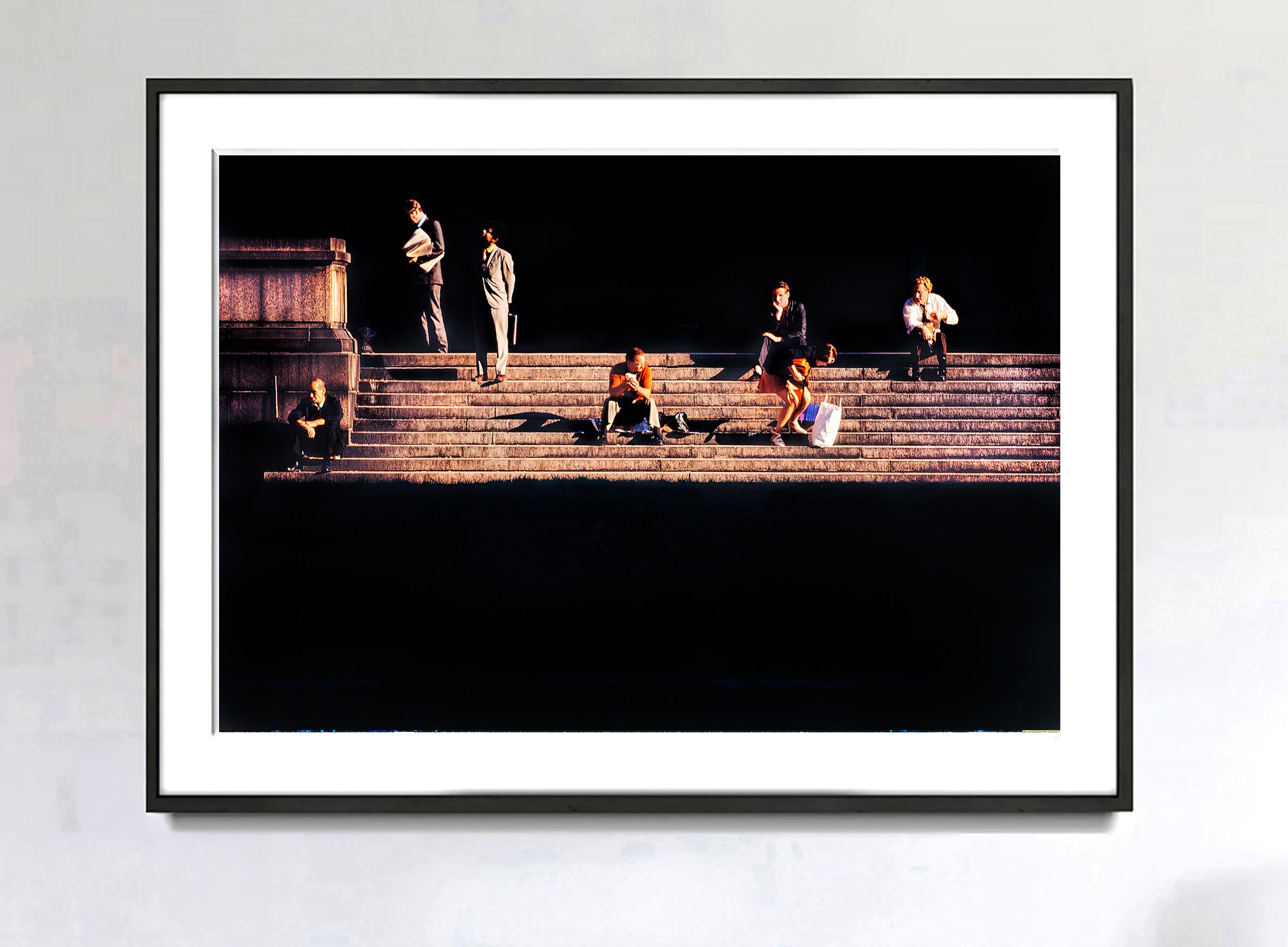 Inspiriert von der Dramatik der Hell-Dunkel-Malerei von Caravaggio, hält Mitchell Funk Figuren auf den Stufen des Bryant Park in Manhattan fest. Vereint durch die späten goldenen Sonnenstrahlen und ihre geografische Lage bleiben die Figuren