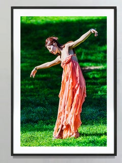 Free Spirited Asian Female Dancing Outdoors against Green Background
