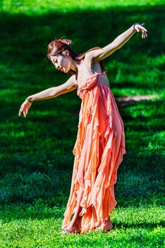 Free Spirited Asian Female Dancing Outdoors against Green Background