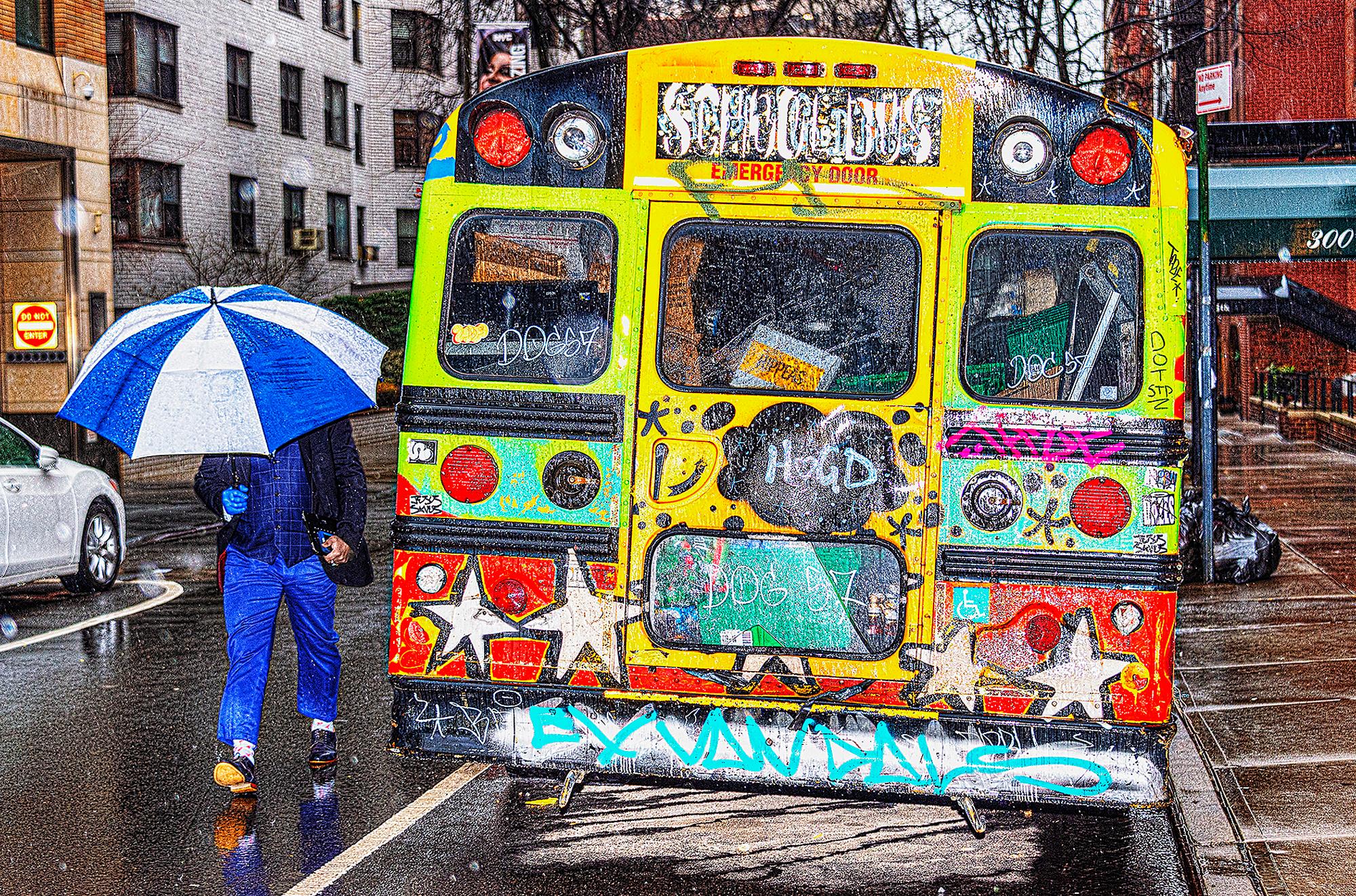 Mitchell Funk Landscape Photograph - A Contrast of Two Art Styles - Graffiti Bus & Blue Umbrella on Rainy Day 