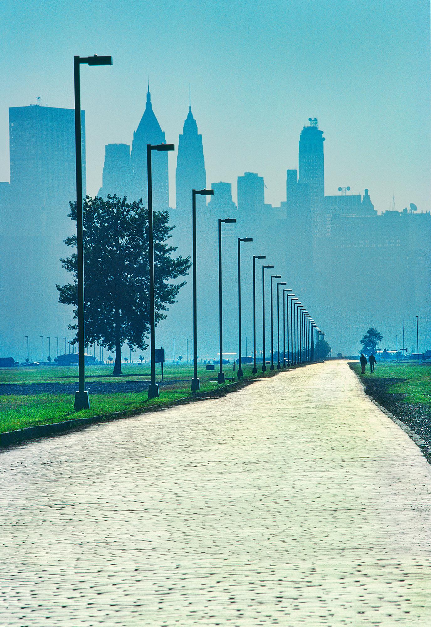 Mitchell Funk Color Photograph – beleuchtet  Sunlit Road Going to New York City Skyline