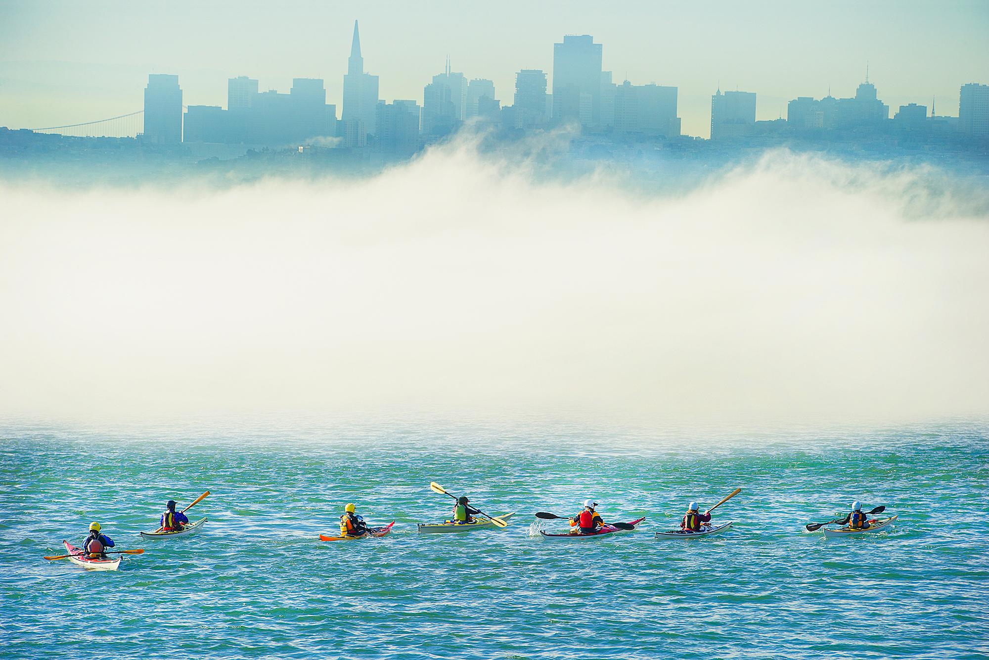Surreale Kayak-Party in Foggy Metaphysical San Francisco Bay mit gedämpfter Skyline