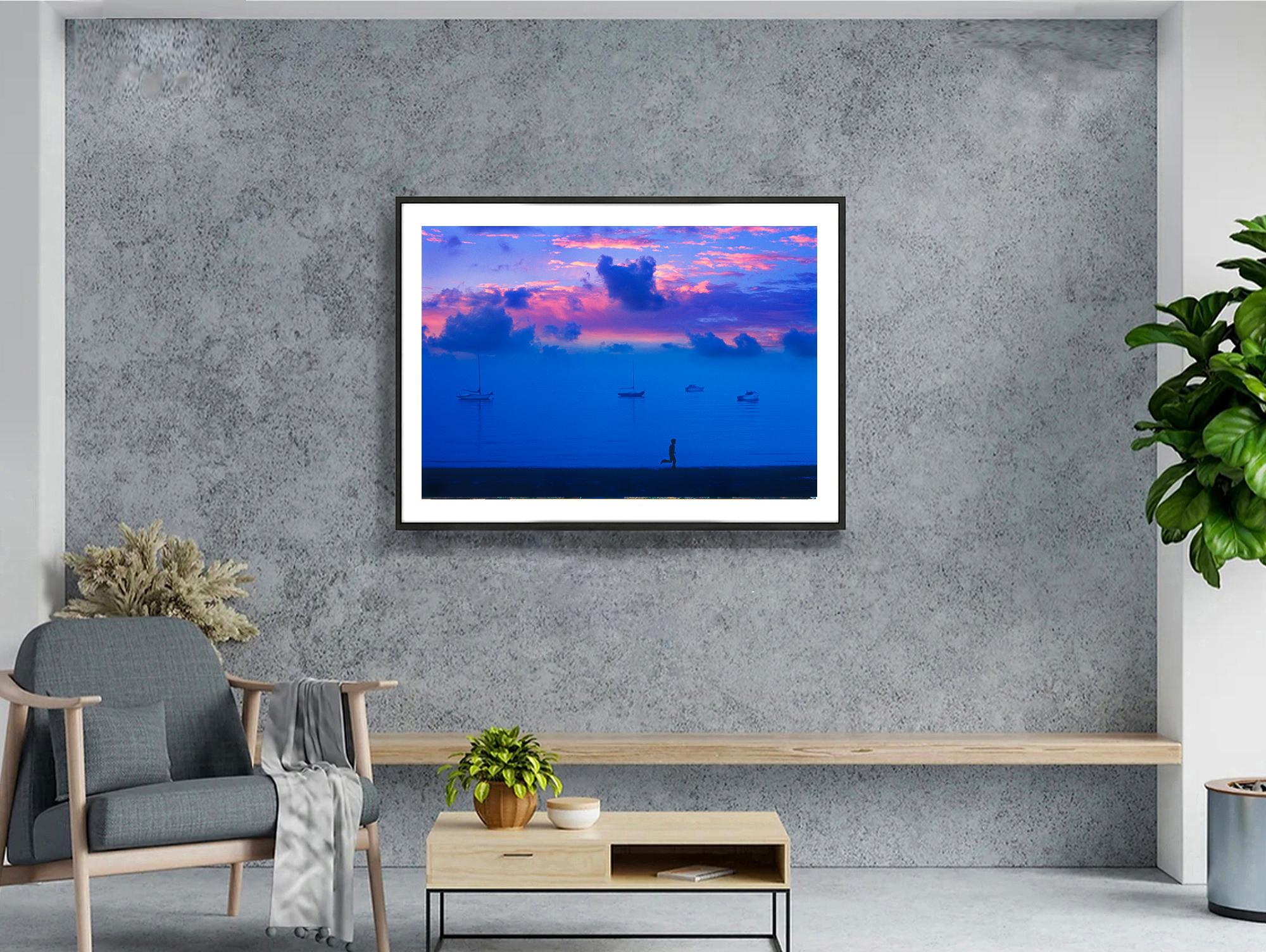Cielo magenta al tramonto , Cielo sereno in blu e magenta  L'uomo che corre e le barche - Photograph di Mitchell Funk