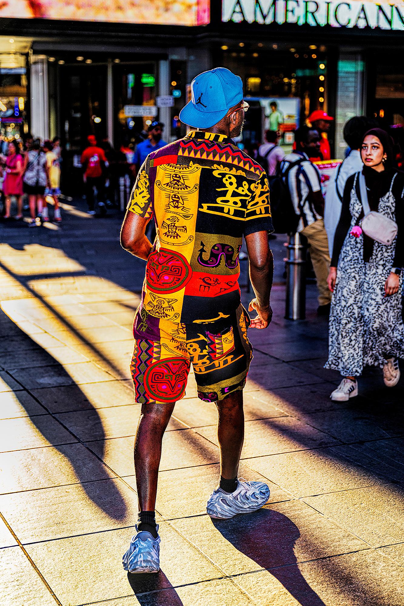 Homme vêtu de vêtements africains colorés éclairés par un faisceau de lumière 