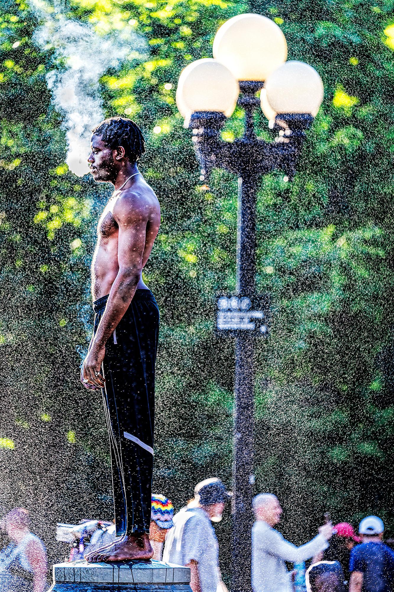 Homme noir musclé réfléchissant dans le Mist de la fontaine