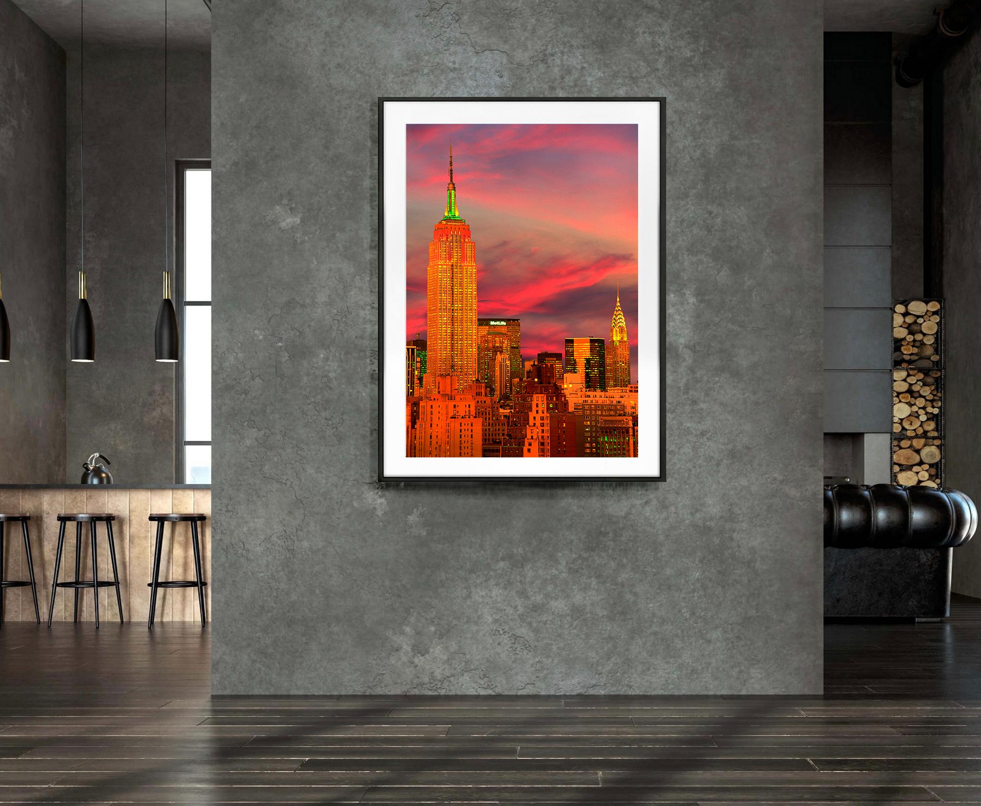 Dieses hochdramatische Foto zeigt einen Dialog zwischen dem Empire State Building und dem Chrysler Building, wie sie 1998 aussahen. 
Der Fotograf Mitchell Funk fängt das Zentrum von New York City in magischem rosa Licht ein. Es fehlen die neuen