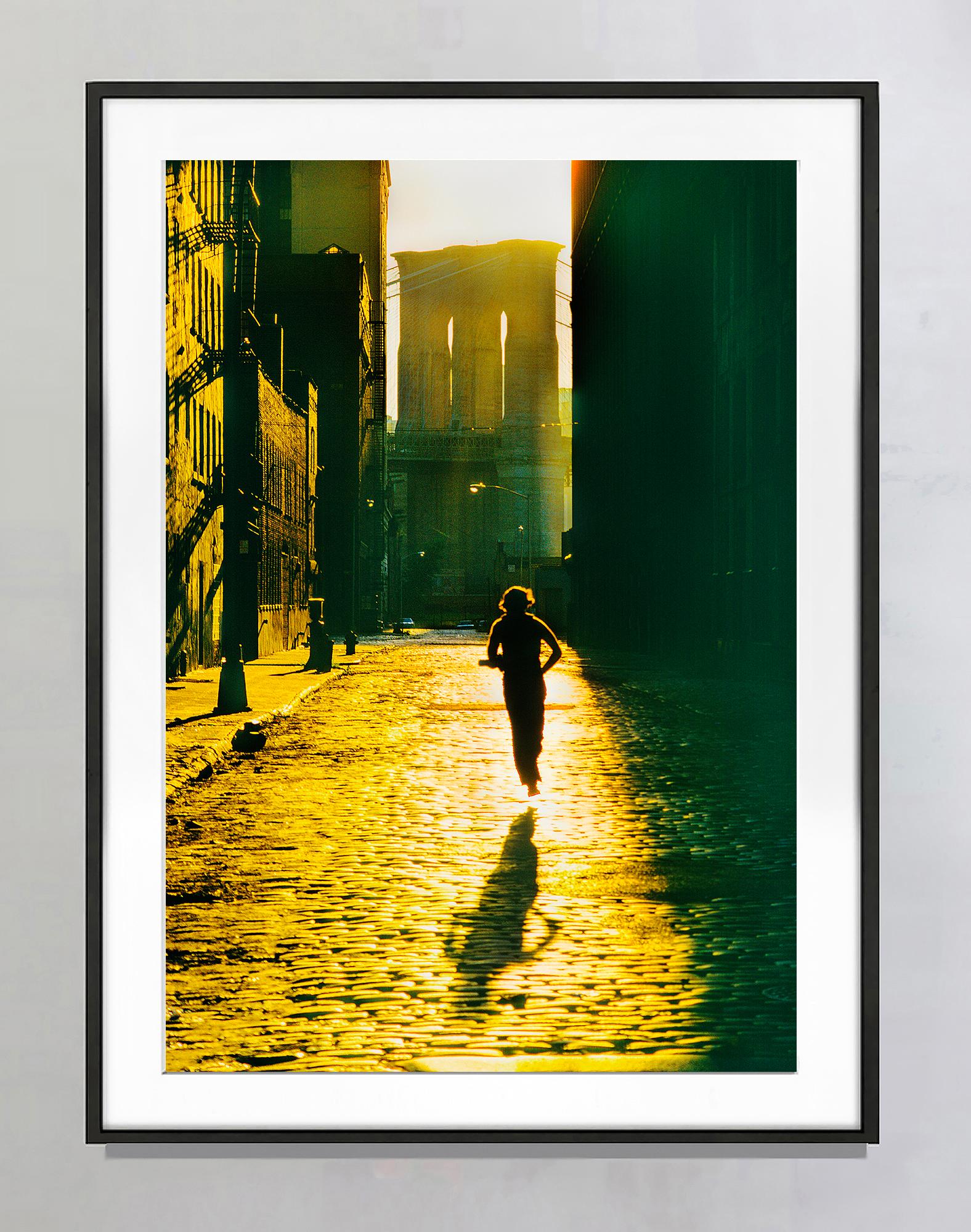 Floating Runner Glides Above Dumbo Cobblestone in Angelic Light - Photograph by Mitchell Funk