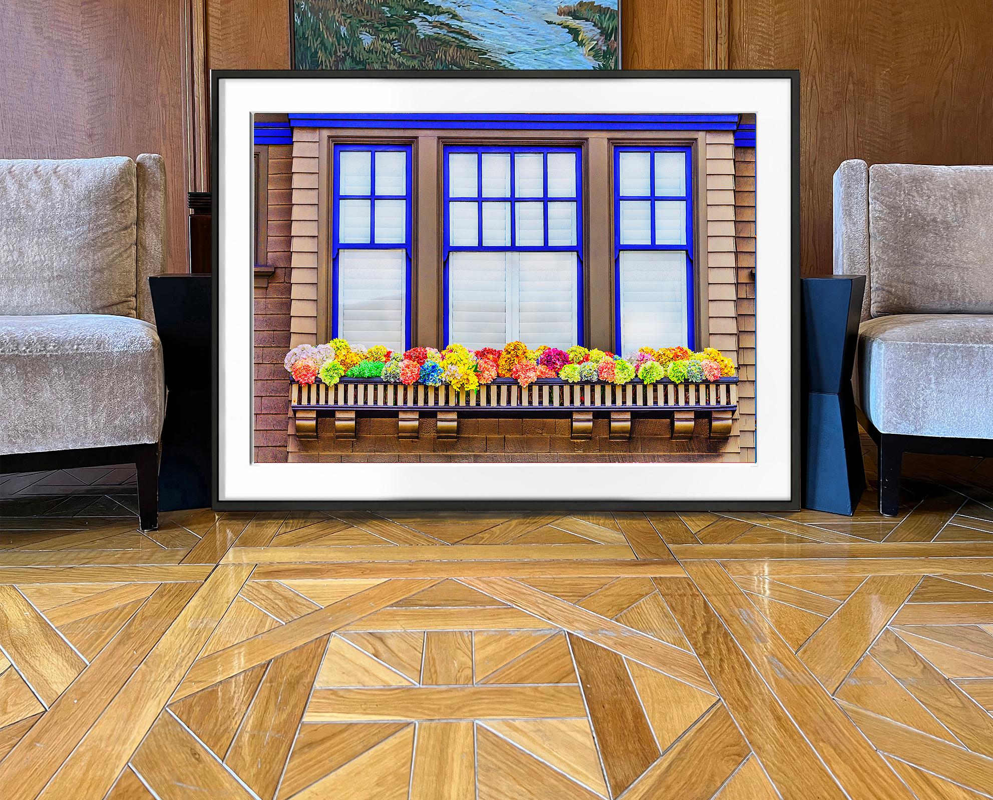 Un alegre despliegue de flores adorna la ventana exterior de una casa de campo. Está sacado directamente de la América de Norman Rockwell. La composición es formal, con líneas rectilíneas pintadas en un profundo azul cobalto que enmarcan un cálido