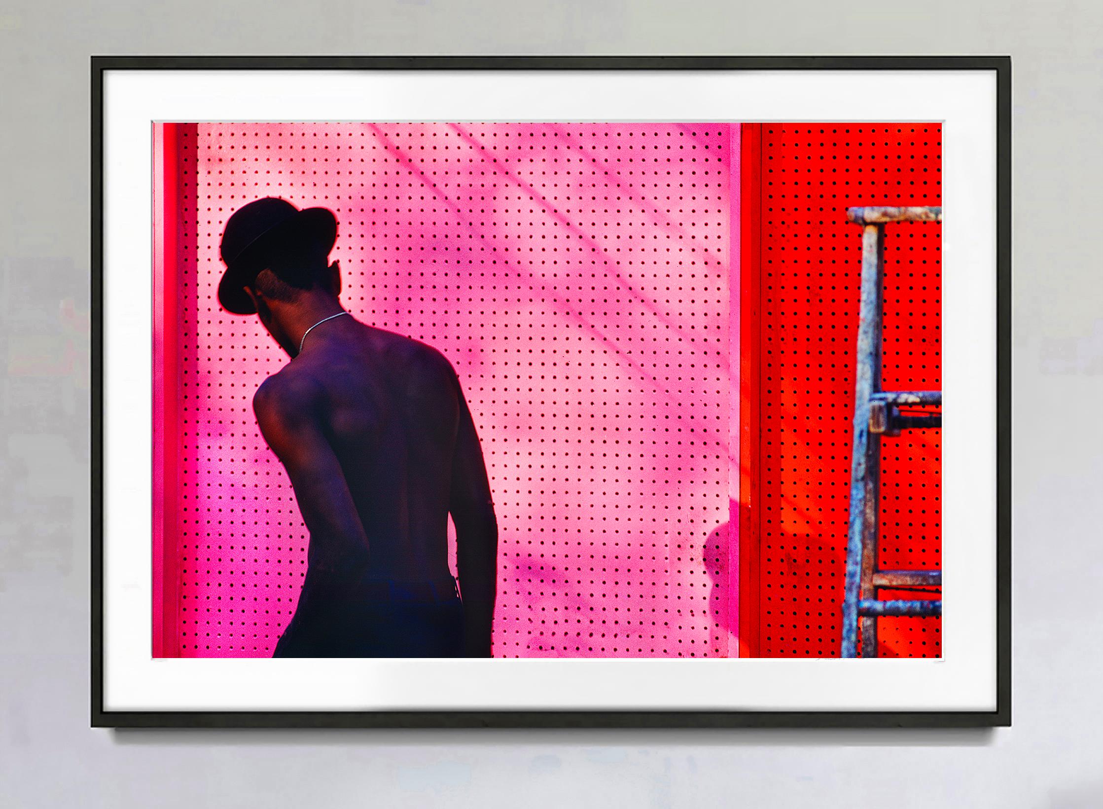 Man sans chemise avec chapeau au-dessus d'un mur rose Chelsea, Manhattan - photographie de rue - Photograph de Mitchell Funk